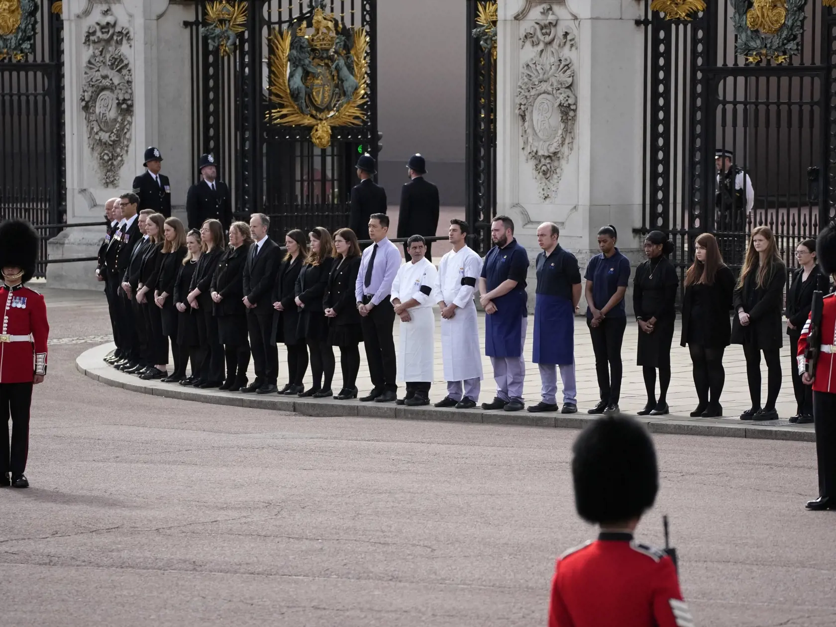 WA 66 Londýn - Zamestnanci Buckinghamského paláca stoja pred vstupom do paláca počas štátneho pohrebu britskej kráľovnej Alžbety II. v Londýne v pondelok 19. septembra 2022. Štátny pohreb panovníčky sa začal vo Westminsterskom opátstve v pondelok o 11.00 h miestneho času (12.00 h SELČ). Alžbeta II., ktorá vládla viac než 70 rokov, zomrela 8. septembra vo veku 96 rokov na zámku Balmoral v Škótsku. Jej pozostatky previezli do Londýna 13. septembra.