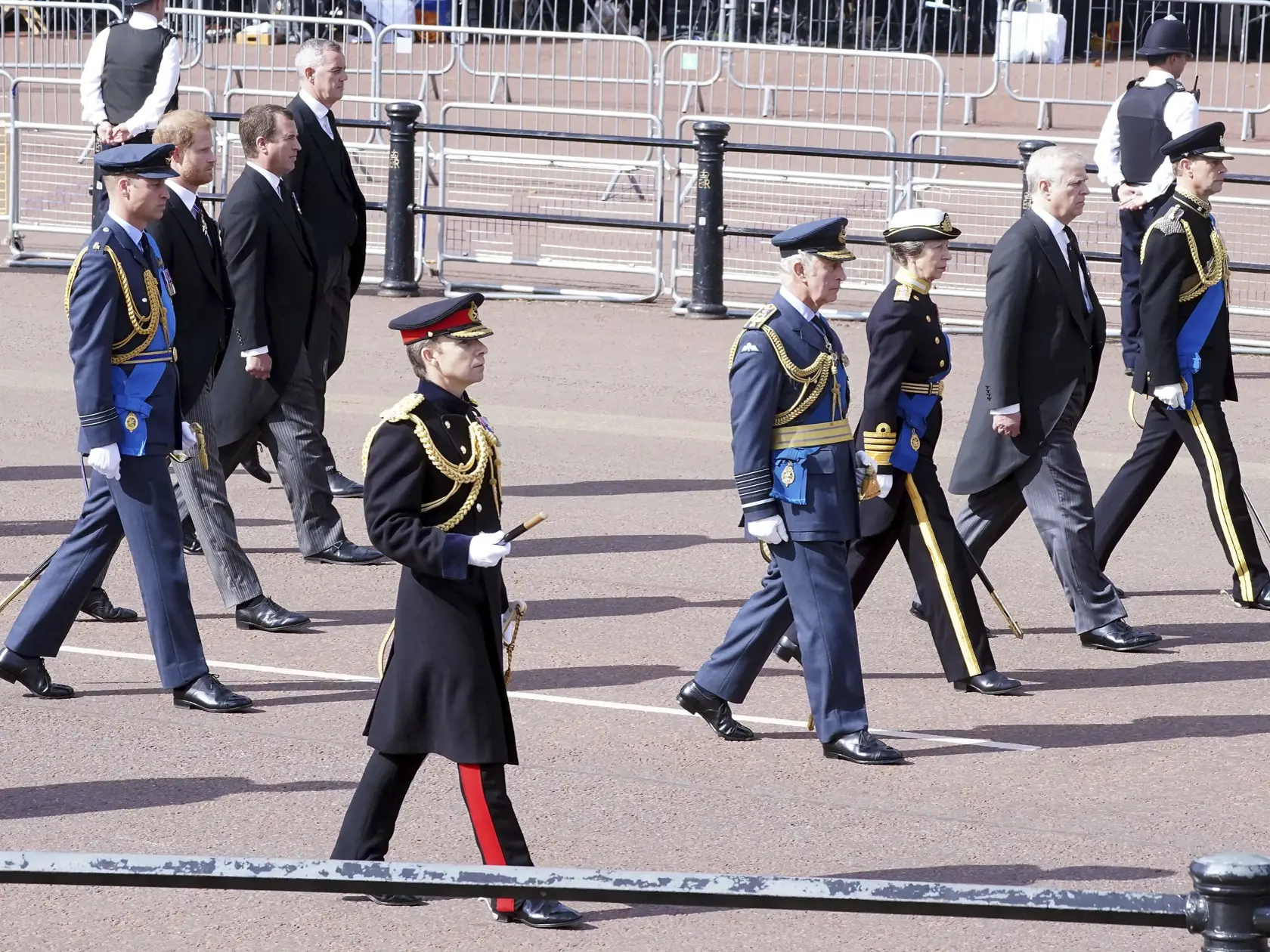 Britský kráľ Charles III. (štvrtý sprava), britská princezná Anna (tretia sprava),  britský princ Andrew (druhý sprava) a britský princ Edward (vpredu vpravo) a v pozadí  Peter Phillips (tretí zľava), britský princ Harry (druhý zľava) a britský princ William, princ z Walesu (vľavo)  kráčajú za rakvou s telesnými pozostatkami zosnulej britskej kráľovnej Alžbety II. počas slávnostnej procesie z Buckinghamského paláca do Westminsterského paláca v Londýne 14. septembra 2022.