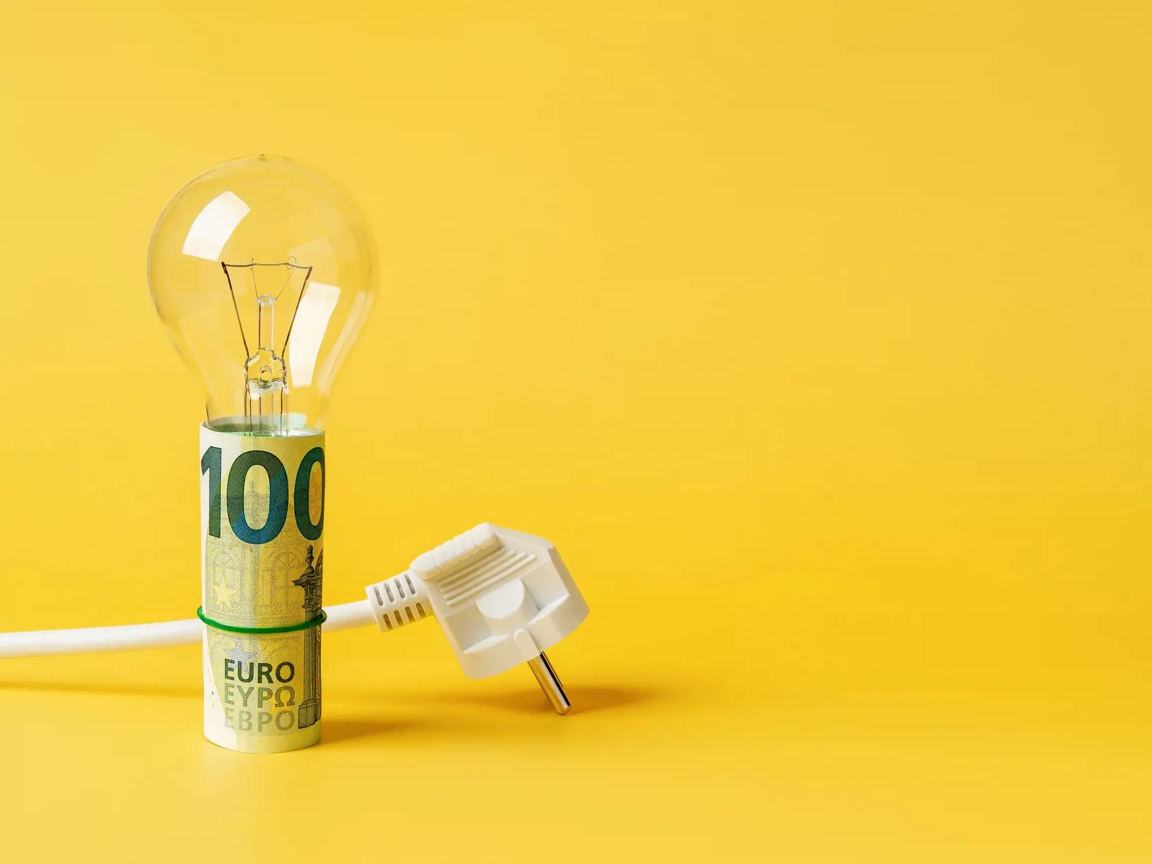 Light,Bulb,On,A,Rolled,100,Euro,Banknotes,And,White
