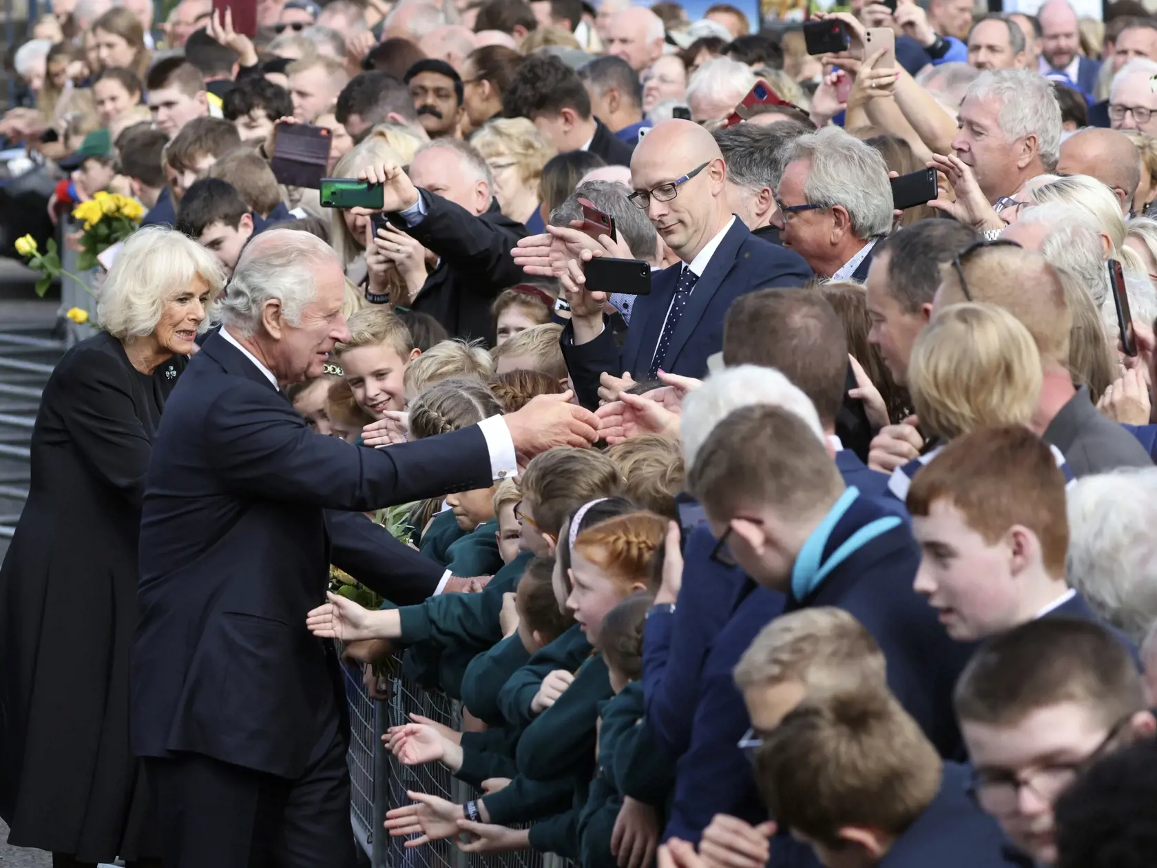 JB 2 Belfast - Britský kráľ Karol III. (druhý zľava) a Camilla, kráľovná manželka (vľavo) sa zdravia s ľuďmi pred zámkom Hillsborough počas ich návštevy v severoírskom Belfaste 13. septembra 2022. Nového britského panovníka Karola III. v nedeľu oficiálne vyhlásili za kráľa v hlavným mestách jednotlivých častí Spojeného kráľovstva - v škótskom Edinburghu, severoírskom Belfaste i metropole Walesu Cardiff. Karol III. nastupuje na trón po svojej matke Alžbete II., ktorá vládla viac než 70 rokov. Tát