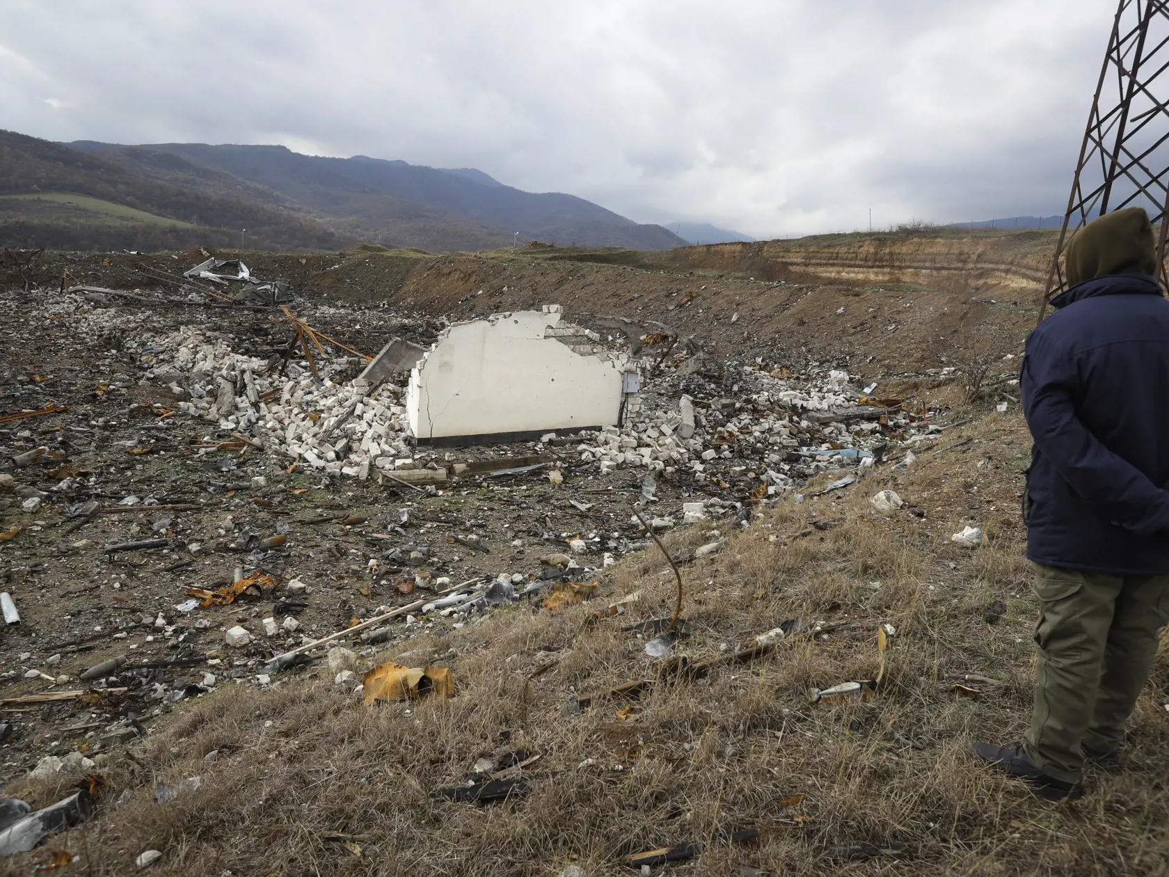 Člen záchranného tímu odmíňovacej organizácie Halo Trust sa pozerá na nevybuchnutú muníciu v zničenom muničnom sklade v azerbajdžanskom meste Aejgestan, na predmestí Stepanakertu 23. novembra 2020. V spornej oblasti Náhorného Karabachu sa 7. septembra obnovili boje medzi Azerbajdžanom a Arménskom.