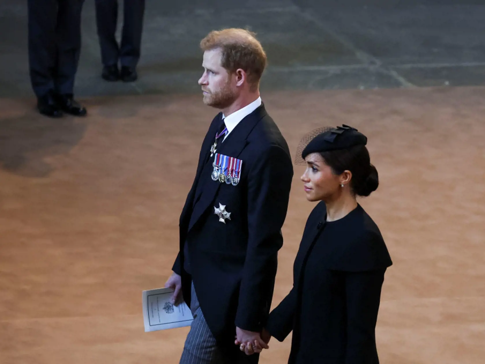 Harry a Meghan počas smútočného pochodu porušili kráľovský protokol, keď sa chytili za ruky.