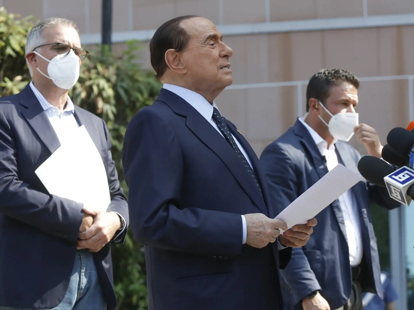 Bývalý taliansky premiér a mediálny magnát Silvio Berlusconi (druhý zľava) a jeho osobný lekár Alberto Zangrillo (vľavo) počas vyhlásenia pre médiá po prepustení z Nemocnice sv. Rafaela, kde bol Berlusconi po pozitívnom teste na nový koronavírus hospitalizovaný od začiatku septembra v Miláne v pondelok 14. septembra 2020.