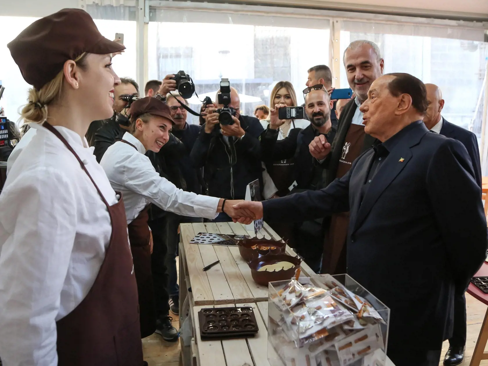 Líder strany Forza Italia a taliansky expremiér Silvio Berlusconi (vpravo) sa zdraví s predavačkami počas podujatia Eurochocolate v talianskom meste Perugia v piatok 18. októbra 2019.