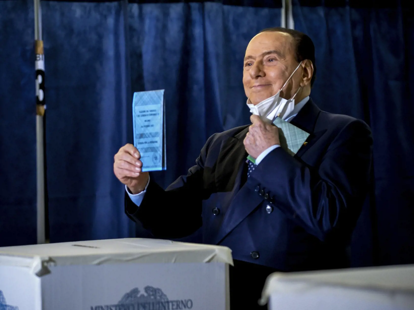Líder talianskeho hnutia Forza Italia  Silvio Berlusconi pózuje fotografom ako hádže do urny svoj hlas počas hlasovania vo voľbách do orgánov miestnej samosprávy vo volebnej miestnosti v Miláne 3. októbra 2021.