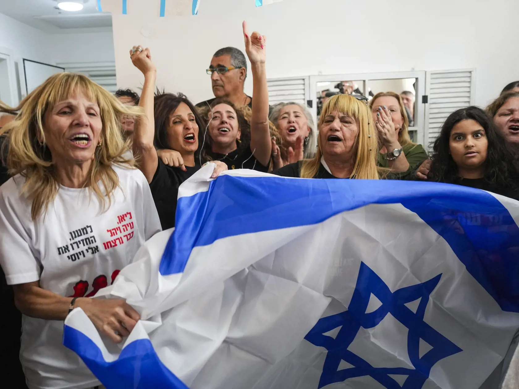 Rodinní príslušníci uneseného izraelského rukojemníka Eliho Šarabiho, ktorého manželku a dve dcéry zabili pri útoku palestínskeho militantného hnutia Hamas na juhu Izraela zo 7. októbra 2023, reagujú na jeho prepustenie zo zajatia Hamasu v Tel Avive v sobotu 8. februára 2025