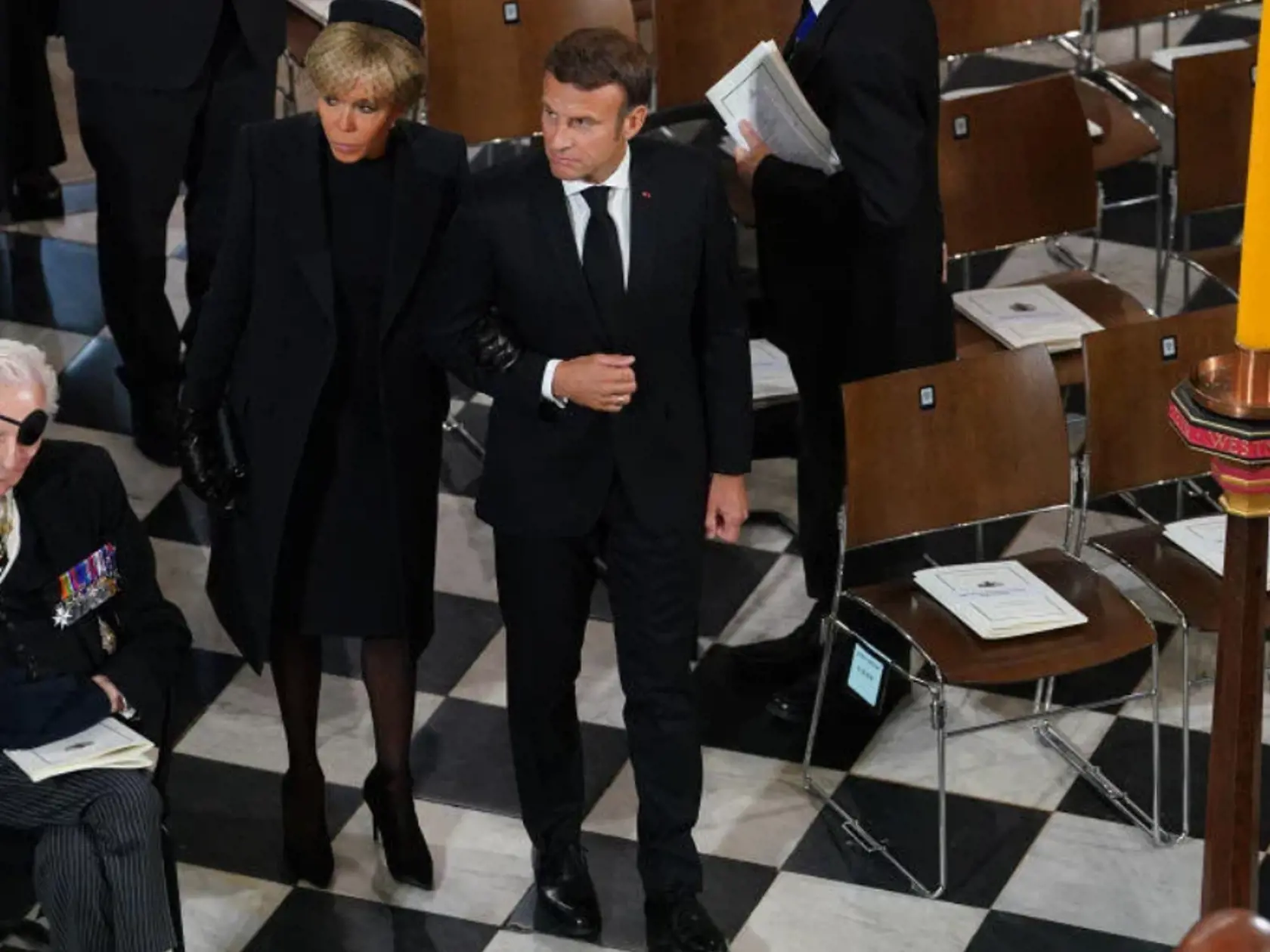 Brigitte Macron ani tentokrát nesklamala a predviedla tradičný francúzsky šarm a chic eleganciu. Prišla v decentných čiernych šatách, ktoré doplnila o kvalitný a dobre padnúci kabát v dĺžke šiat. Ako pokrývku hlavy si zvolila aristokratický módny doplnok: okrúhly čierny klobúčik so vzdušnou sieťkou. „Brigitte Macron je ukážkou akoby to malo vyzerať. Jednoduché, vkusné s patričným francúzskym šarmom. Dodržala tiež predpísaný protokol,“ myslí si Andrea Ziegler.