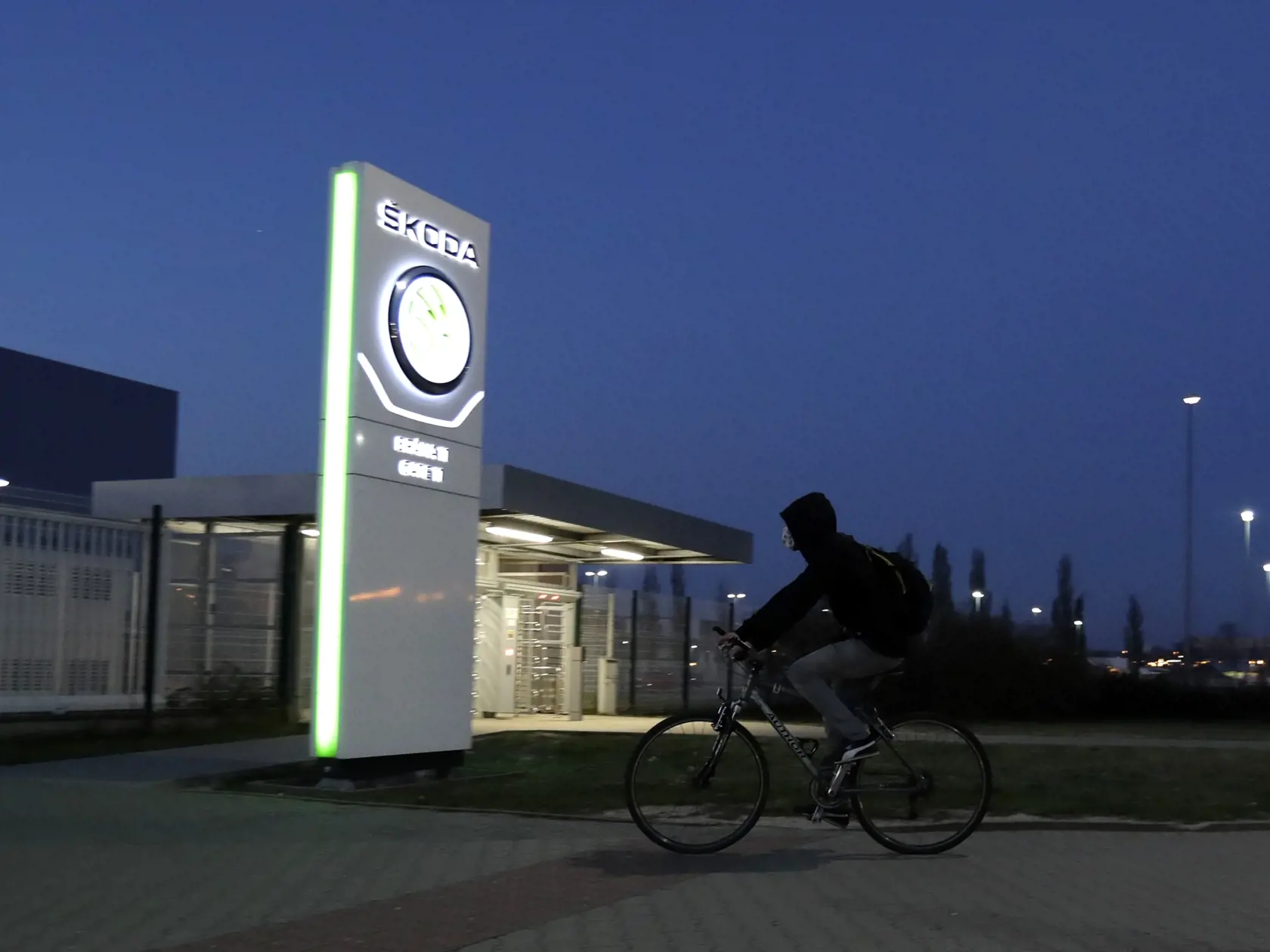 WA 7 Mladá Boleslav - Zamestnanec automobilky Škoda Auto prichádza na bicykli na rannú smenu do závodu v českom meste Mladá Boleslav, v ktorom sa opätovne spustila výroba v pondelok 27. apríla 2020. Automobilka Škoda Auto od pondelka obnovuje výrobu vo všetkých troch svojich českých závodoch. Tie boli zatvorené od 18. marca z dôsledku koronavírusovej pandémie. FOTO TASR/AP 

An employee rides his bicycle to the Skoda car factory as it reopens in Mlada Boleslav, Czech Republic, Monday, April 27, 