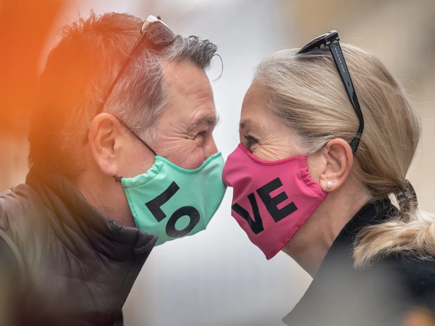 WA 36 Mníchov - Jörg a Petra s ochrannými rúškami, ktoré vytvárajú slovo láska, sa zdravia nosmi počas stretnutia v Mníchove v pondelok 27. apríla 2020. Viaceré štáty sveta, vrátane Nemecka, uvoľnili od pondelka niektoré opatrenia proti šíreniu koronavírusu. Od tohto týždňa bude možné v nemeckej spolkovej krajine Bavorsko za určitých podmienok znova otvoriť obchody do 800 metrov štvorcových. V obchodoch a mestskej hromadnej doprave musia ľudia nosiť rúško alebo inú ochranu nosa a úst. FOTO TASR/
