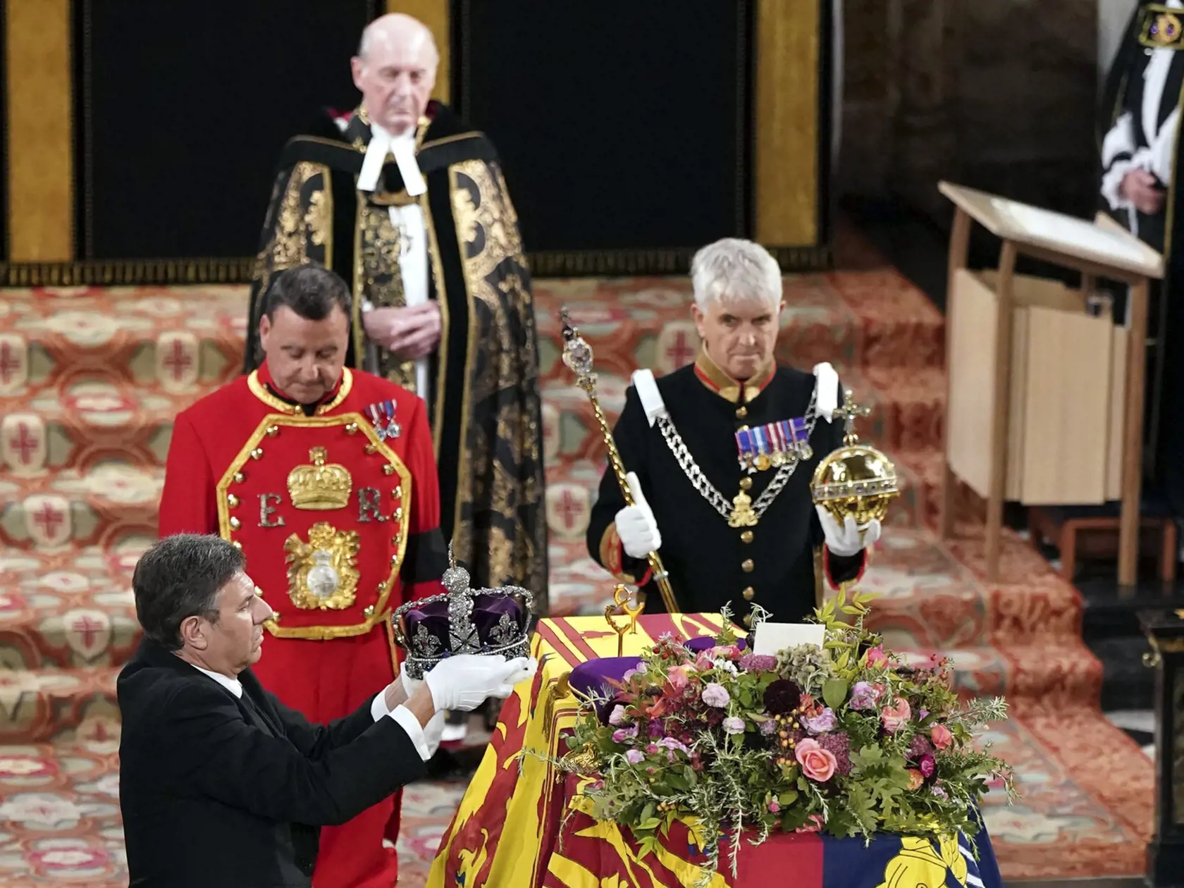 Na snímke královský klenotník berie kráľovskú korunu z rakvy s pozostatkami zosnulej britskej kráľovnej Alžbety II. počas obradu rozžehnania sa s telom v Kaplnke svätého Juraja na hrade Windsor v pondelok 19. septembra 2022.
