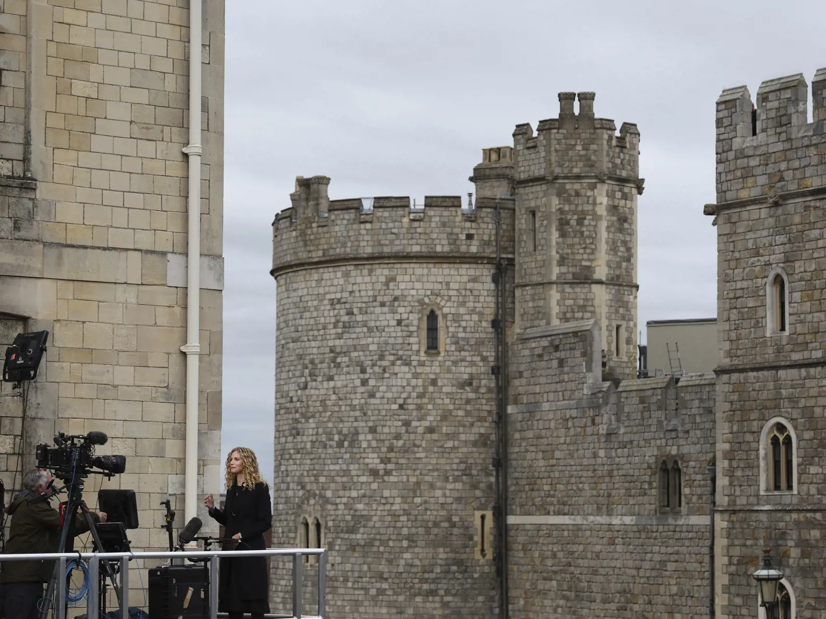 WA 37 Windsor - Novinárka natáča reportáž pred Windsorským hradom v deň štátneho pohrebu britskej kráľovnej Alžbety II. v pondelok 19. septembra 2022. Štátny pohreb panovníčky sa začal vo Westminsterskom opátstve v pondelok o 11.00 h miestneho času (12.00 h SELČ). Po smútočnom obrade rakvu prevezú kráľovským pohrebným vozidlom na Windsorský hrad nachádzajúci sa západne od Londýna. Tam sa uskutoční pohrebný obrad v hradnej Kaplnke sv. Juraja a súkromný akt uloženia rakvy do krypty. Kráľovná spoči