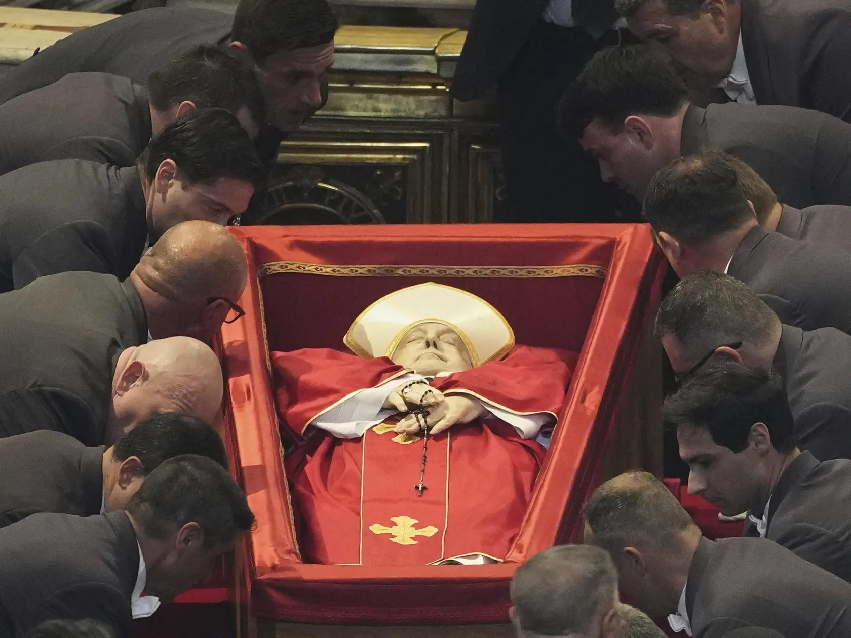 JB 27 Vatikán - Ceremoniál prevozu tela zosnulého pápeža Františka v Bazilike sv. Petra vo Vatikáne 23. apríla 2025. Otvorenú rakvu s telom zosnulého pápeža Františka vystavili v stredu v Bazilike sv. Petra vo Vatikáne, kam ju preniesli z Domu sv. Marty, kde počas svojho pontifikátu býval a kde na Veľkonočný pondelok aj zomrel. Informovala o tom agentúra AFP, píše TASR. Drevenú rakvu v sprievode ôsmich príslušníkov Švajčiarskej gardy vniesli do Baziliky sv. Petra za hlaholu jej zvonov a následne ju uložili na vyvýšený stupienok pred hlavný oltár. Nasledovali Litánie za všetkých svätých a bohoslužba slova, počas ktorej zaznelo evanjelium podľa sv. Jána, prosby veriacich a modlitba Otče náš. FOTO TASR/AP 

The body of Pope Francis is placed into St. Peter's Basilica at the Vatican, Wednesday, April 23, 2025, where he will lie in state for three days. (AP Photo/Andrew Medichini, Pool)