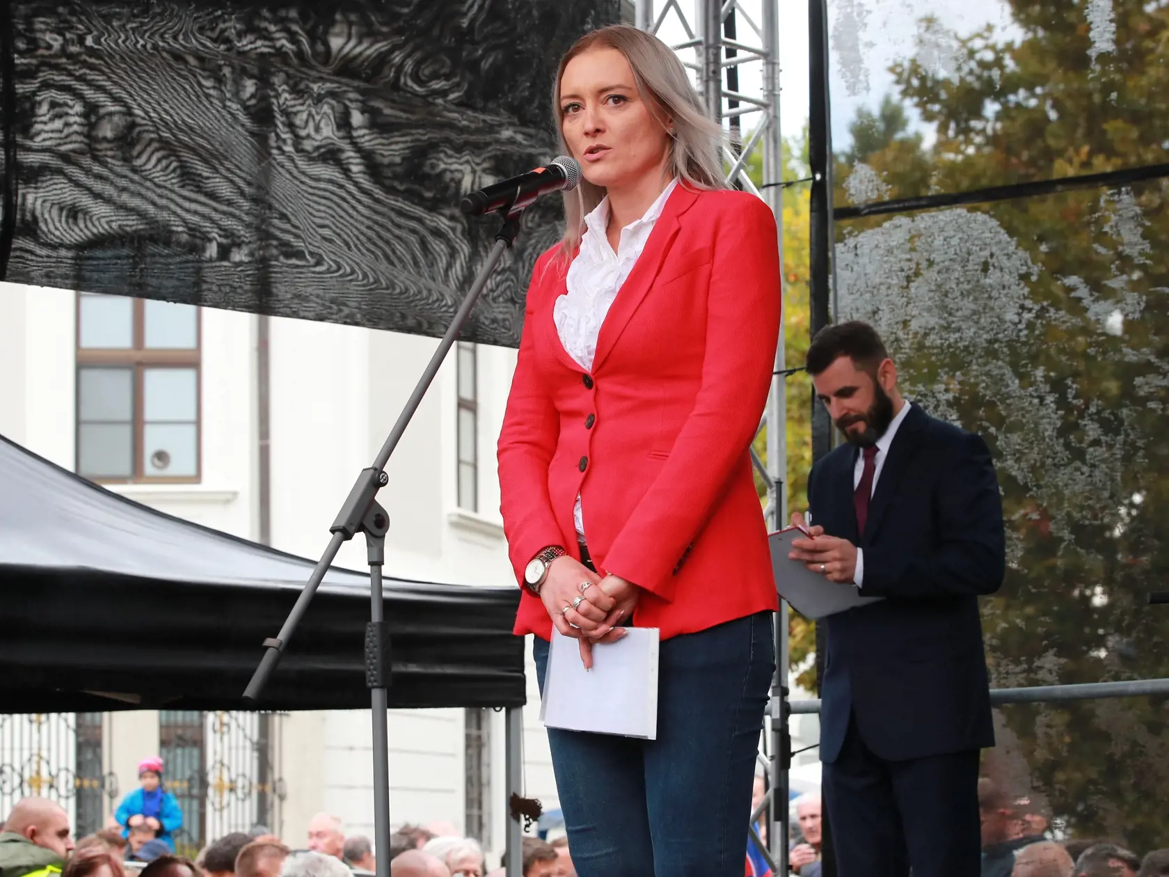 Protestné zhromaždenie organizované pred budovou Prezidentského paláca na Hodžovom námestí sa začalo štátnou hymnou Slovenskej republiky. Aj napriek daždivému počasiu zišli stovky ľudí. Ako prvý vystúpil herec Marek Ťapák, za ním právnička Judita Laššáková.