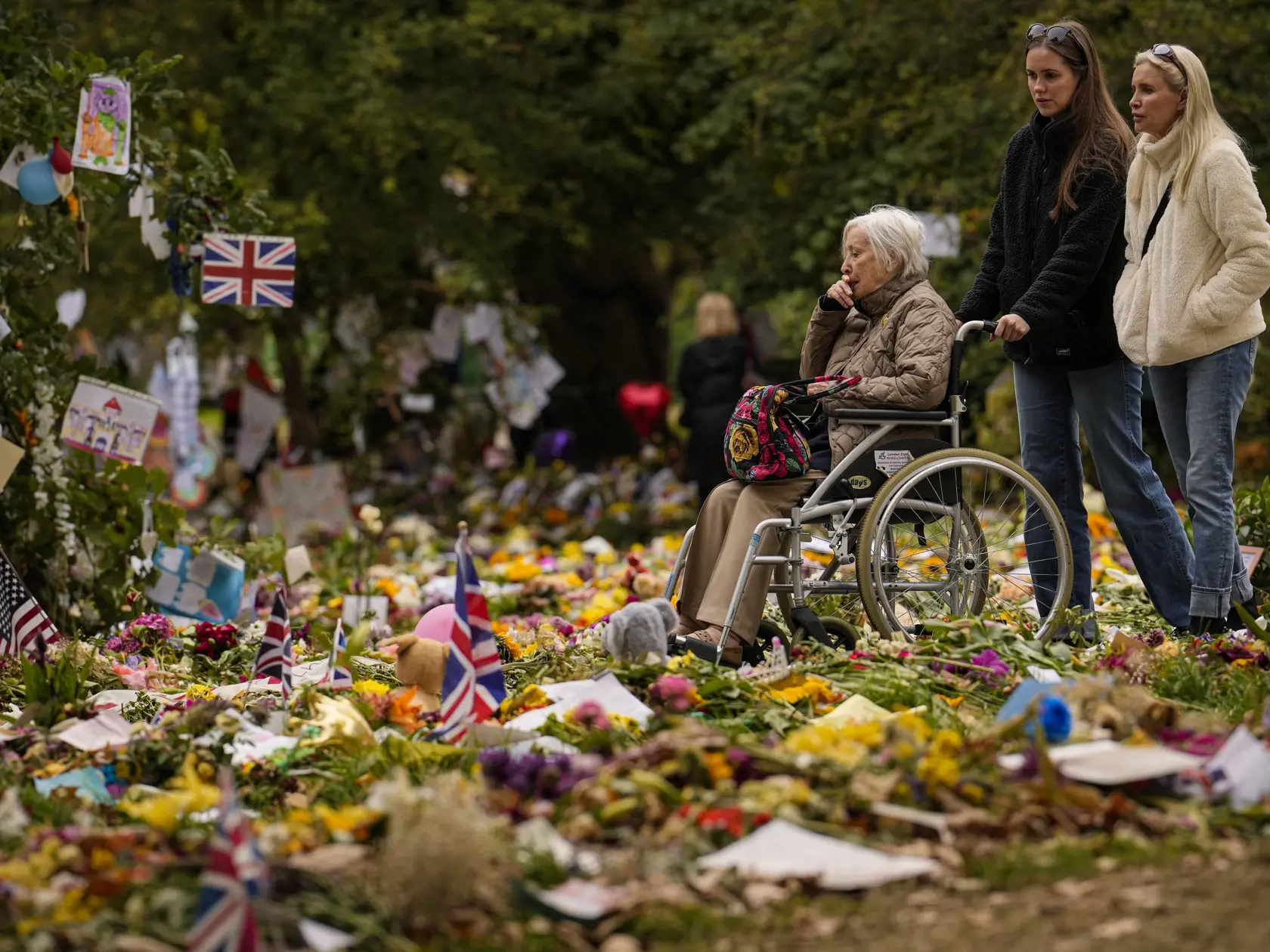Ľudia prinášajú kvety na pamiatku zosnulej britskej kráľovnej Alžbety II. do Green Parku, jedného z ôsmich kráľovských parkov v Londýne, deň po panovníčkinom pohrebe.