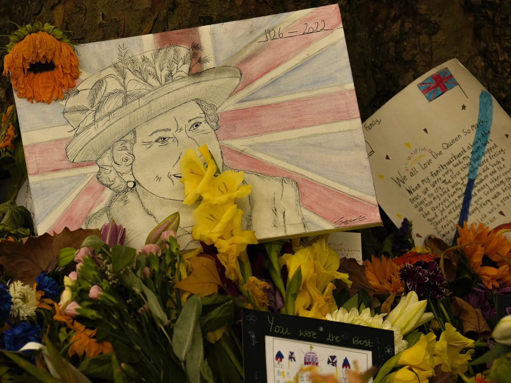 Pdobizeň britskej kráľovnej Alžbety II. a kartičky s odkazmi sú medzi kvetmi v Green Parku, jednom z ôsmich kráľovských parkov v Londýne, deň po panovníčkinom pohrebe.