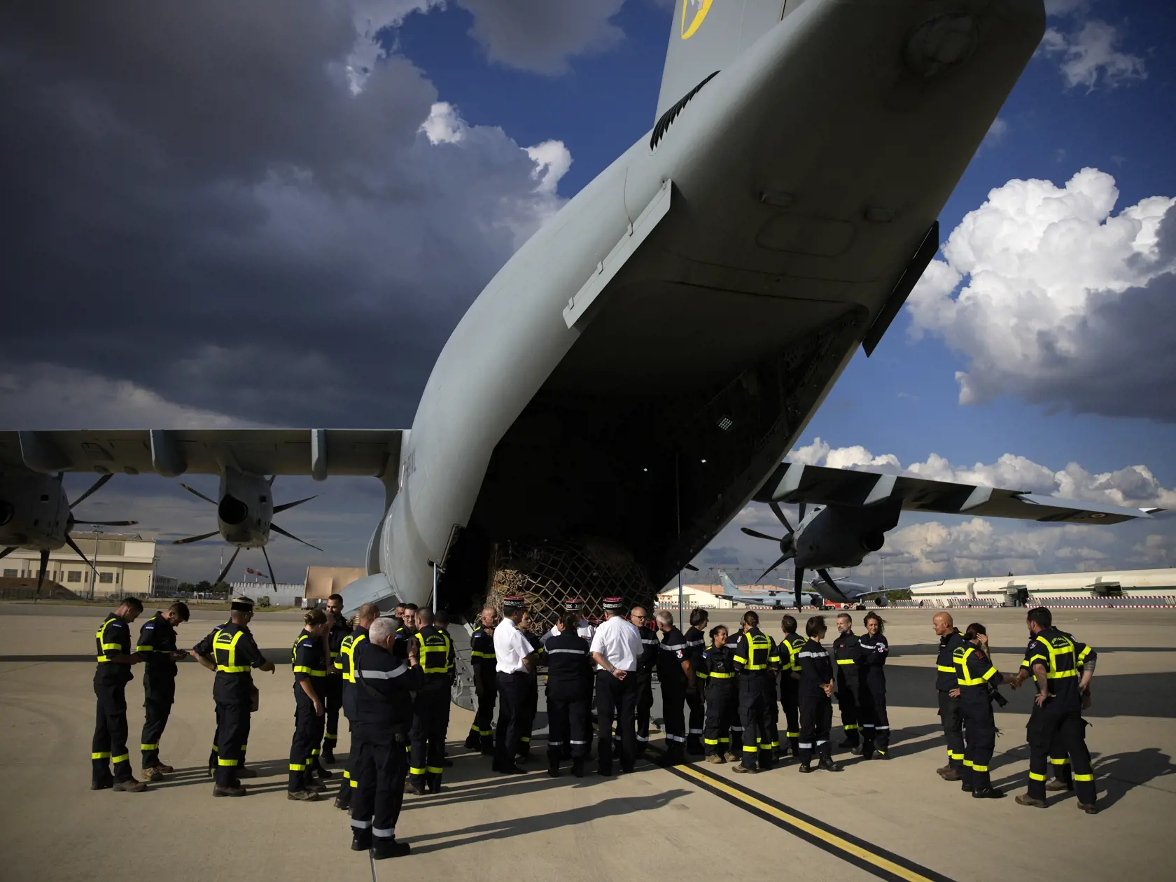 JB 23 Istres - Francúzski dobrovoľníci čakajú pred cargo lietadlom počas nakladania boxov s humanitgárnou pomocou pre Líbyu postihnutú ničivými záplavami po búrke Daniel, na vojenskej základni v meste Istres na juhu Francúzska 13. septembra 2023. Najmenej 30.000 ľudí prišlo o strechu nad hlavou v meste Darna na východe Líbye v dôsledku ničivých záplav spôsobených búrkou Daniel, vyhlásila v stredu Medzinárodná organizácia pre migráciu, ktorá patrí pod Organizáciu Spojených národov. TASR o tom inf