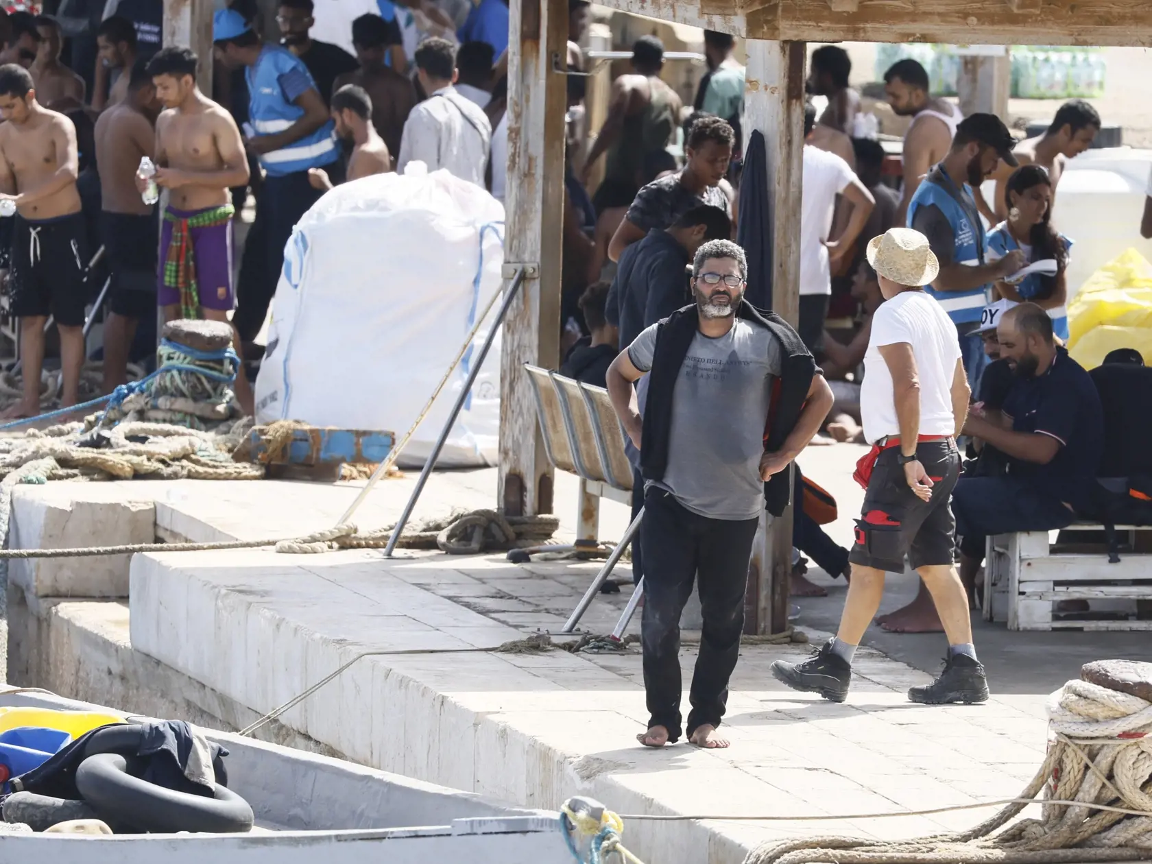 JB 28 Lampedusa - Migranti, ktorých zachránilo  plavidlo talianskej pobrežnej stráže stoja v doku  prístavu talianskeho ostrova Lampedusa 18. septembra 2023 deň po tom, ako tento ostrov navštívila predsedníčka Európskej komisie Ursula von der Leyenová. V Stredozemnom mori je potrebné posilniť letecké aj námorné hliadkovanie v záujme boja proti nelegálnej migrácii. Počas nedeľňajšej návštevy juhotalianskeho ostrova Lampedusa, ktorý v súčasnosti zažíva silný nápor migrantov, to uviedla predsedníčk