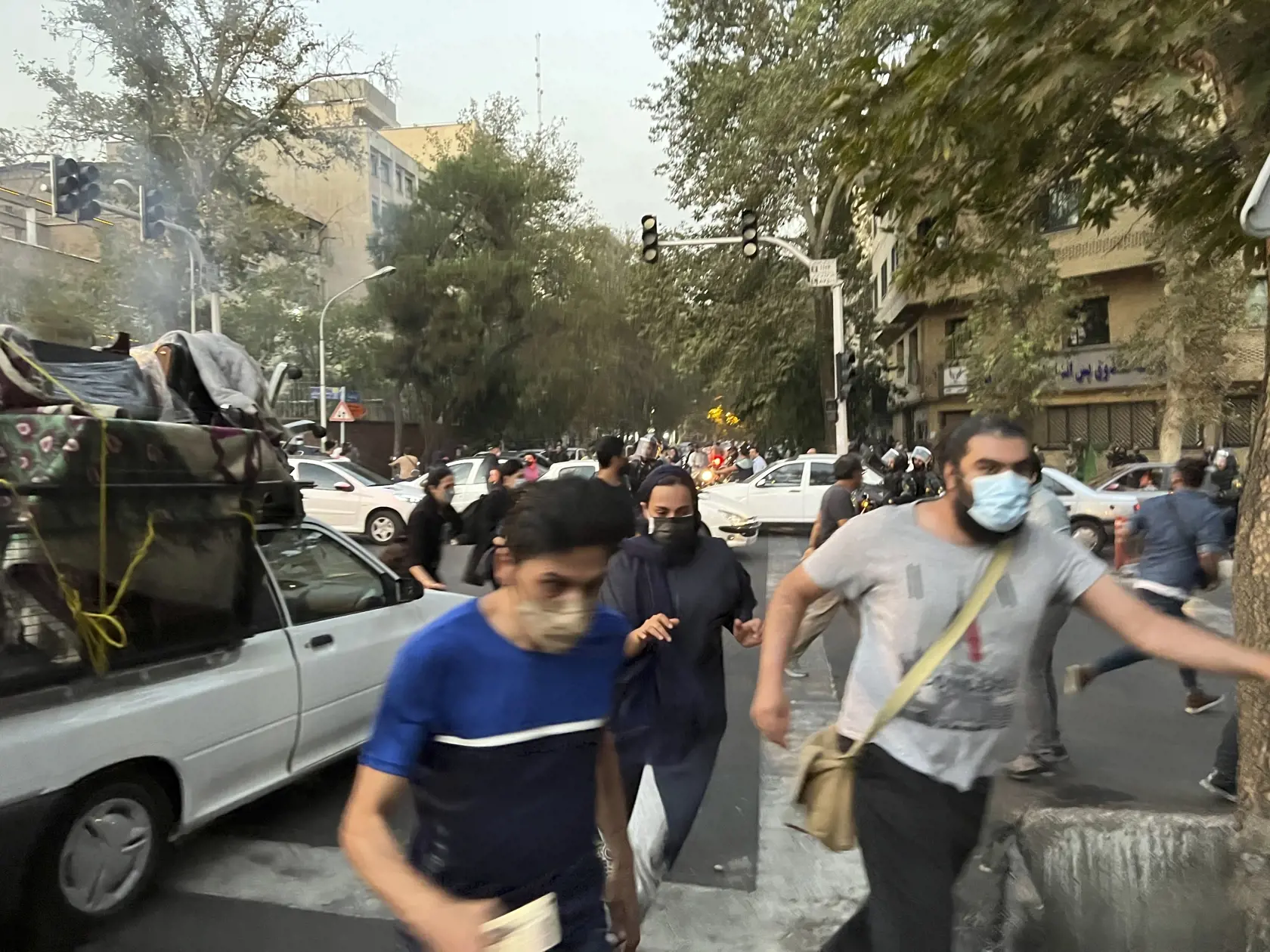 WA 39 Teherán - agentúre Associated Press (AP), a ktorú získala agentúra AP mimo Iránu, ľudia utekajú pred policajtmi počas protestu proti smrti mladej iránskej ženy Mahsá Amíníovej v centre Teheránu.