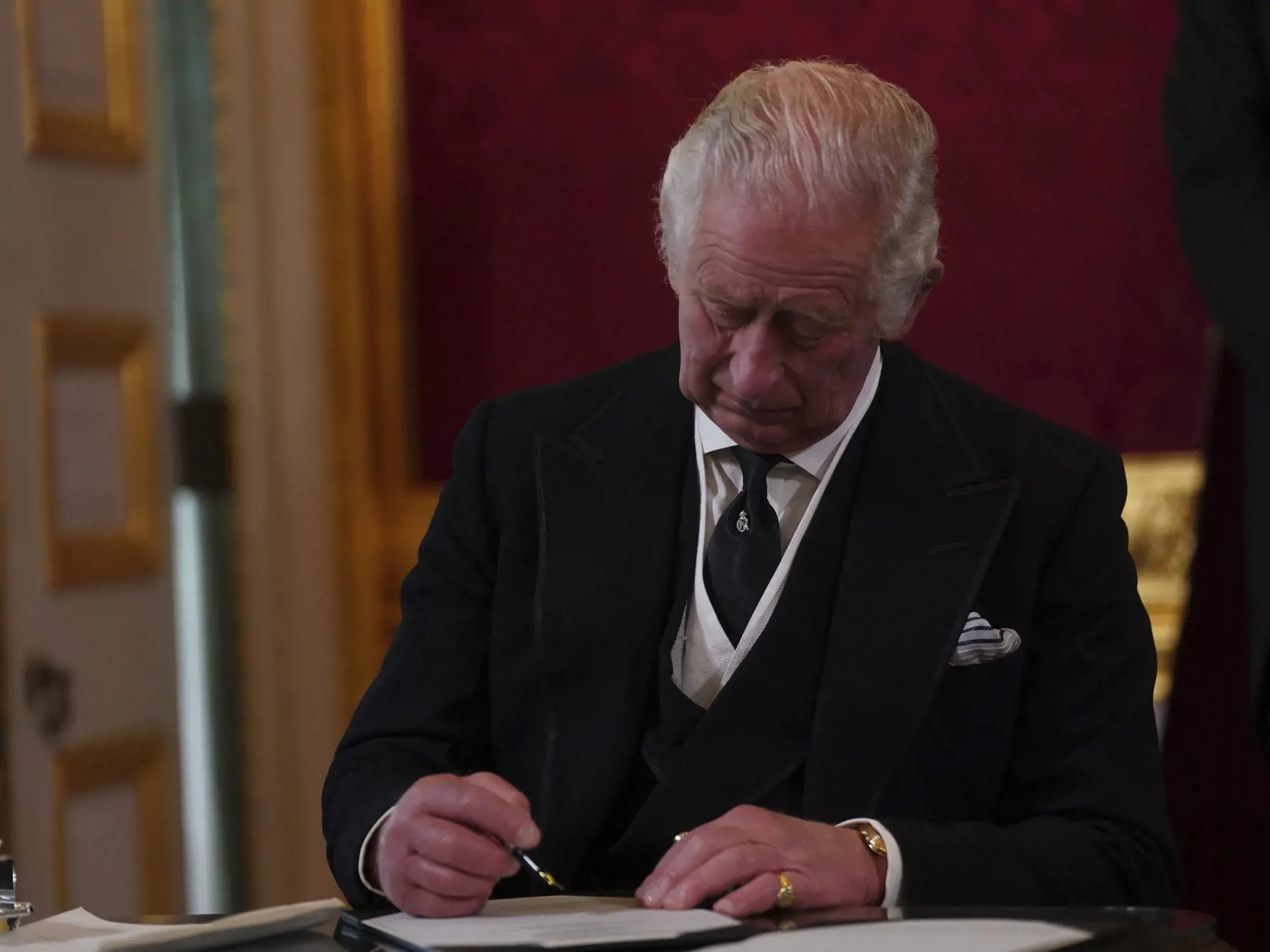 Na snímke britský kráľ Charles III. podpisuje prísahu počas zasadnutia rady pre nástupníctvo trónu v Paláci svätého Jakuba v Londýne 10. septembra 2022.