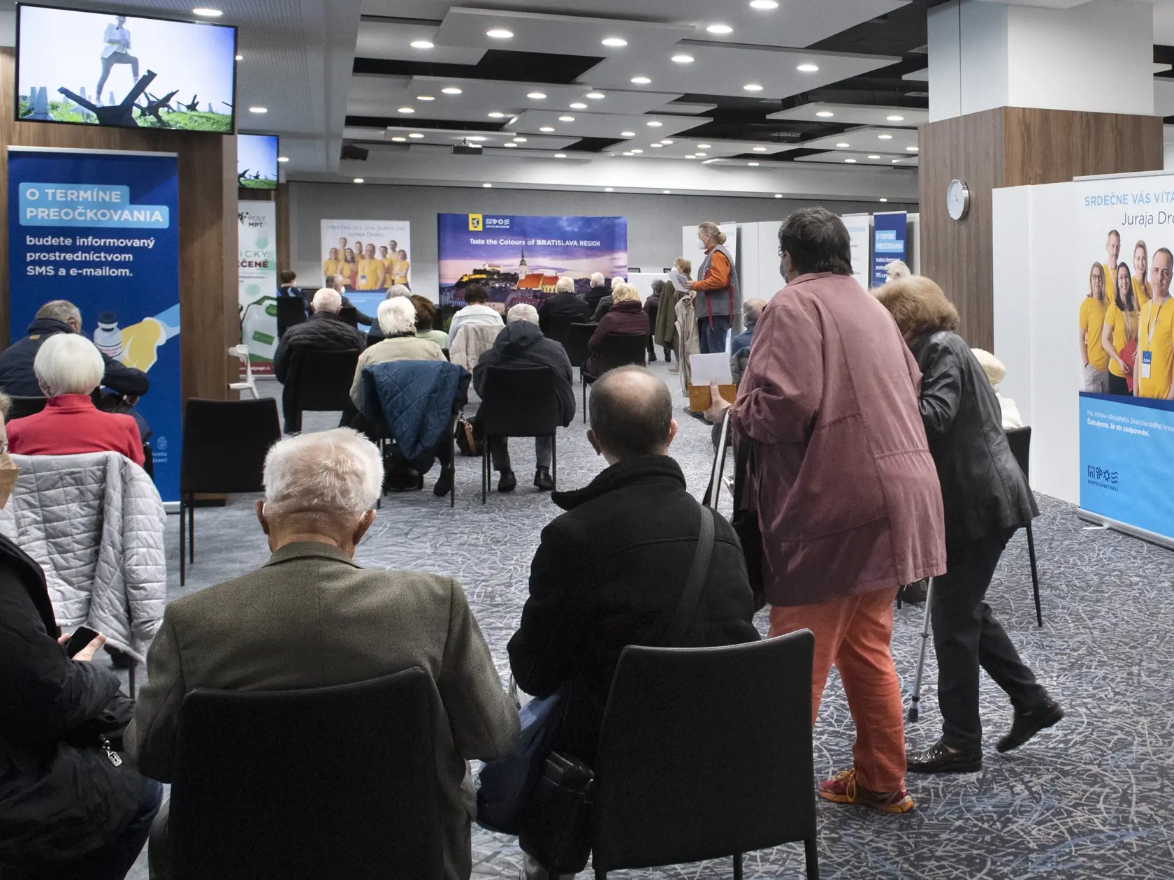 Na snímke ľudia čakajú po zaočkovaní proti ochoreniu Covid-19 v priestoroch NFŠ 6. novembra 2021 v Bratislave.