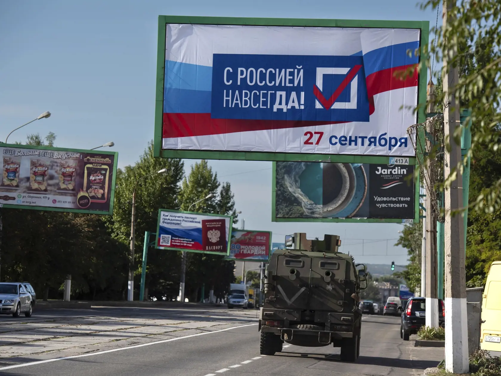 Vojenské vozidlo prechádza okolo bilbordu s nápisom "S Ruskom navždy, 27. september" pred referendom o pripojení Luhanskej samozvanej republike na východe Ukrajiny k Rusku vo štvrtok 22. septembra 2022.