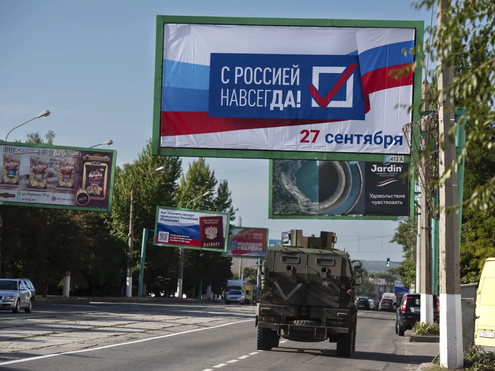 WA 5 Luhansk - Vojenské vozidlo prechádza okolo bilbordu s nápisom "S Ruskom navždy, 27. september" pred referendom o pripojení Luhanskej samozvanej republike na východe Ukrajiny k Rusku vo štvrtok 22. septembra 2022. V samozvaných republikách na východe Ukrajiny – Doneckej a Luhanskej, ako aj v Ruskom okupovaných častiach Chersonskej oblasti na juhu a Záporožskej oblasti na juhovýchode Ukrajiny, sa majú konať  v termíne od 23. do 27. septembra "referendá" o ich pripojení k Rusku. FOTO TASR/AP  