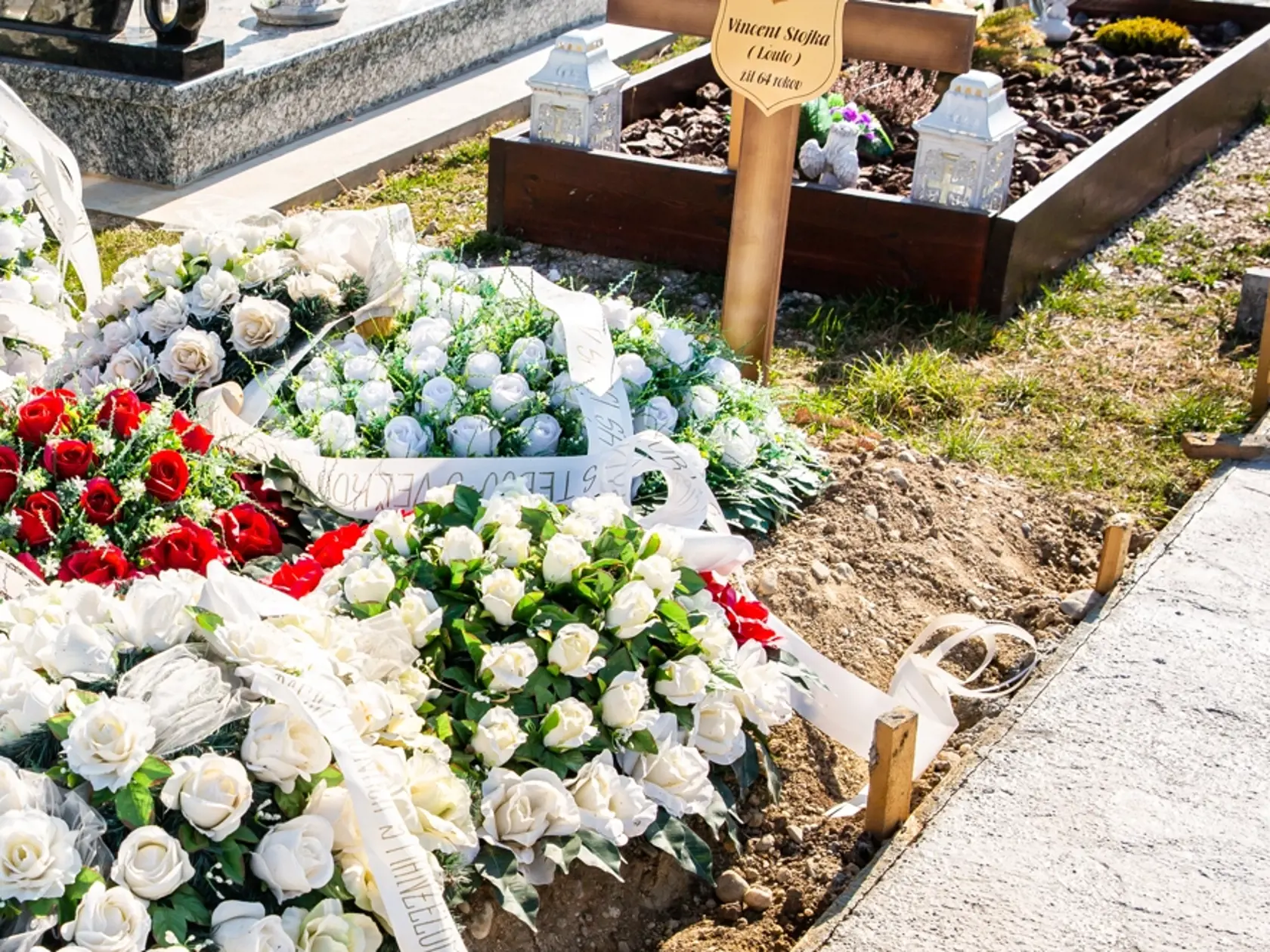 Hrob Jendovho brata s vencami z umelých kvetov.