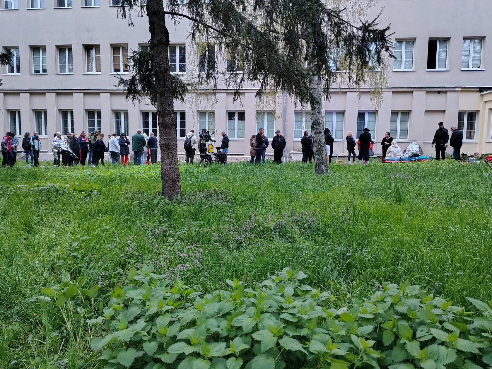 Evakuovaní obyvatelia pred bytovým domom.