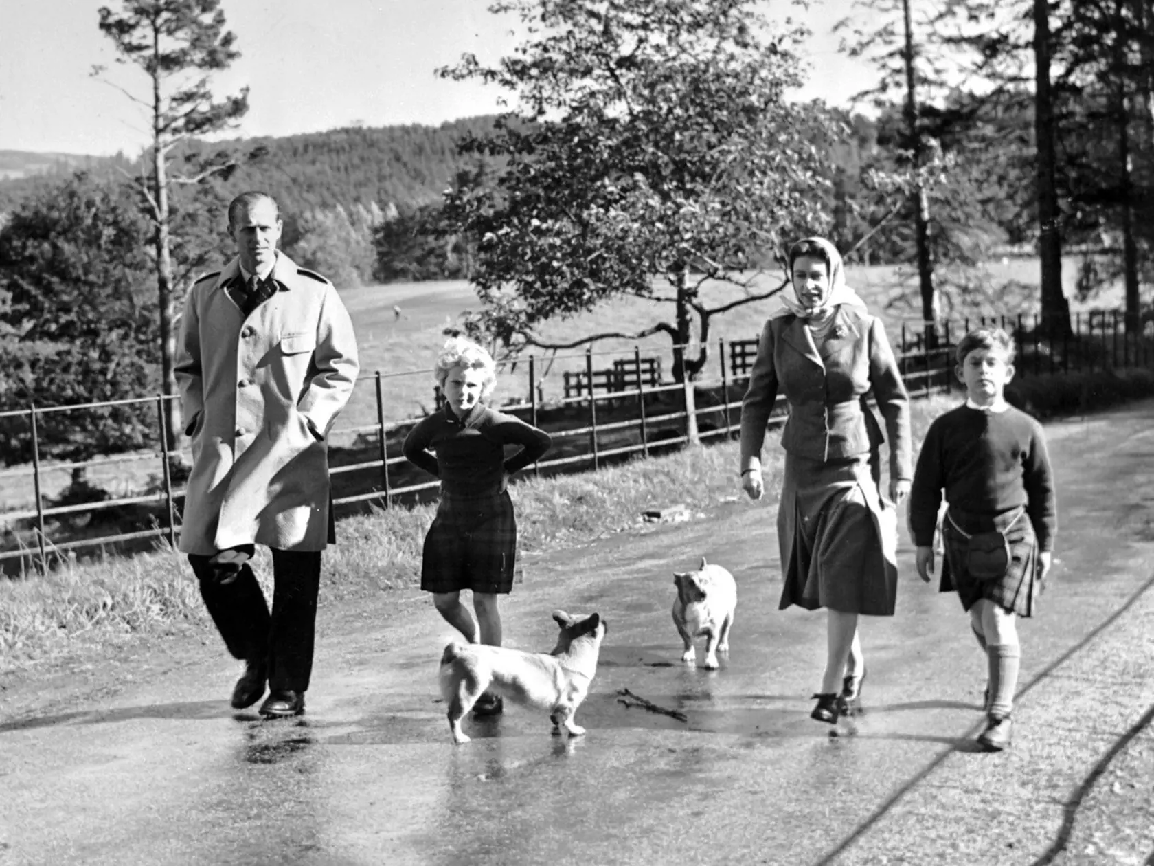 Kráľovská rodinka na prechádzke. Deti: vľavo princezná Anna, vpravo princ Charles.