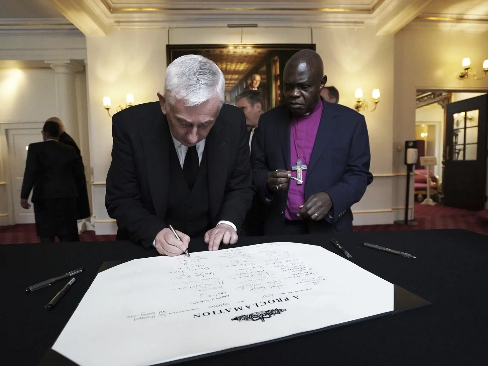 Na snímke vľavo predseda Dolnej snemovne britského parlamentu Lindsay Hoyle podpisuje vyhlásenie o nástupe nového britského kráľa Karola III. v Paláci svätého Jakuba v Londýne 10. septembra 2022. Britská premiérka Liz Trussová  a vysokopostavení členovia vlády v sobotu popoludní zložili prísahu vernosti novému britskému kráľovi Karolovi III. v Dolnej Snemovni britského parlamentu. Ako prvý zložil prísahu predseda Dolnej snemovne britského parlamentu Lindsay Hoyle. FOTO TASR/AP