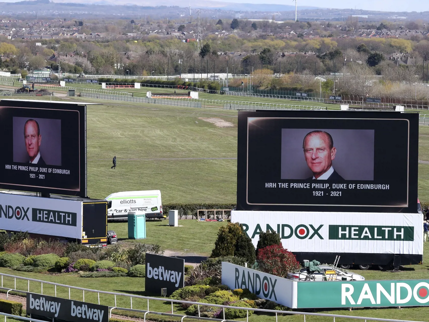 KK9 Liverpool - Na veľkoplošných obrazovkách fotografie zosnulého britského princa Philipa pred druhým dňom Veľkej národnej steeplechase na závodisku Aintree naďaleko Liverpoolu 9. apríla 2021 v Londýne. Britský princ Philip, manžel kráľovnej Alžbety II., zomrel v piatok vo veku 99 rokov. Oznámil to Buckinghamský palác.  "Jeho kráľovská výsosť zomrela dnes ráno pokojne na Windsorskom zámku," dodal palác s tým, že ďalšie informácie zverejnia v náležitom čase. FOTO TASR/AP
Video screens show pictu