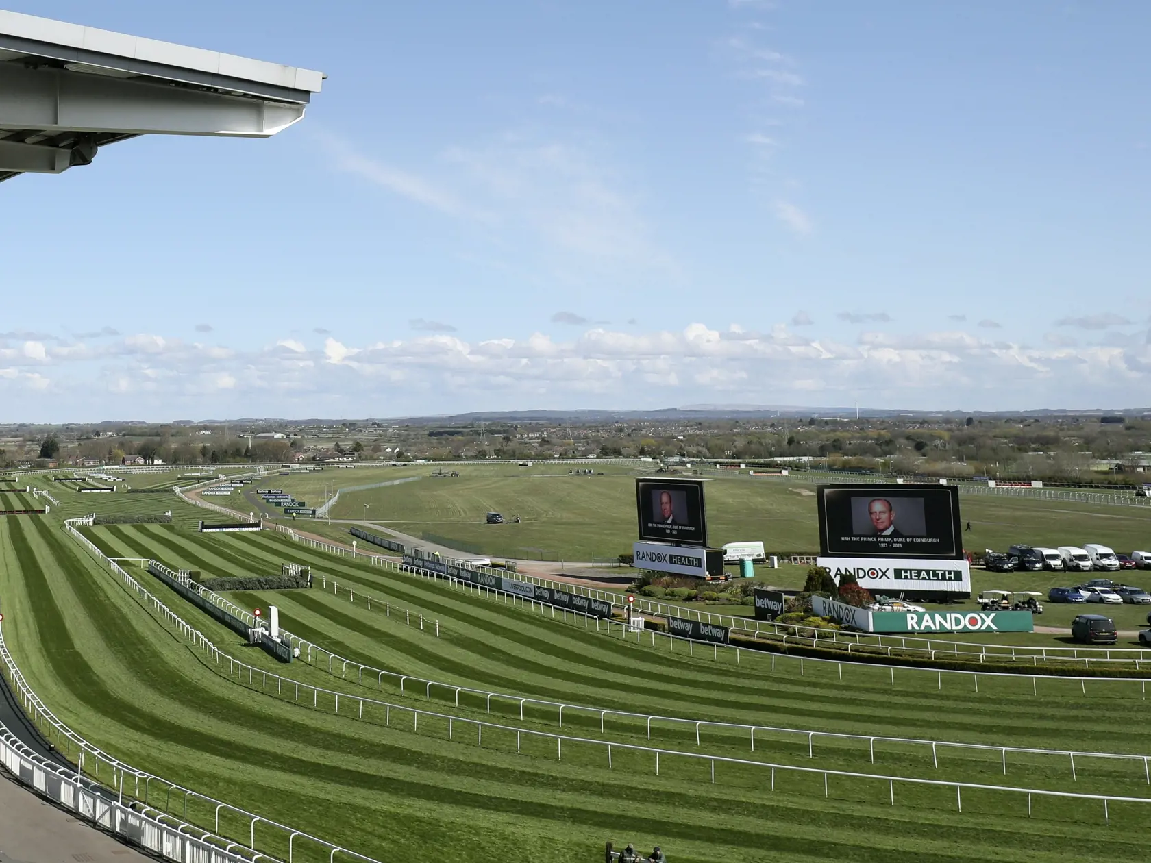 KK10 Liverpool - Na veľkoplošných obrazovkách fotografie zosnulého britského princa Philipa pred druhým dňom Veľkej národnej steeplechase na závodisku Aintree naďaleko Liverpoolu 9. apríla 2021 v Londýne. Britský princ Philip, manžel kráľovnej Alžbety II., zomrel v piatok vo veku 99 rokov. Oznámil to Buckinghamský palác.  "Jeho kráľovská výsosť zomrela dnes ráno pokojne na Windsorskom zámku," dodal palác s tým, že ďalšie informácie zverejnia v náležitom čase. FOTO TASR/AP
Video screens show pict
