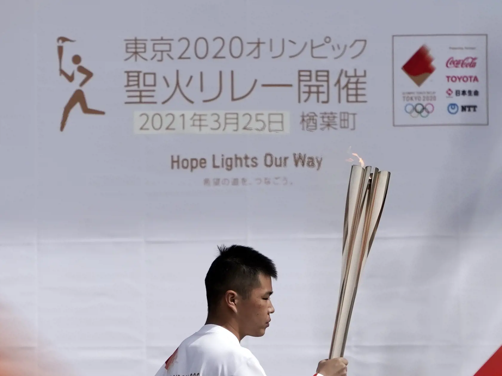 WA 4 Naraha - Devätnásťročný Mahiro Abe z Narahy nesie olympijskú pochodeň počas štartu štafety s olympijskou pochodňou hier v Tokiu v Narahe, v prefektúre Fukušima vo štvrtok 25. marca 2021. Štafeta sa začala v J-Village, čo je futbalový tréningový komplex neďaleko jadrovej elektrárne Fukušima, kde sa pred 10 rokmi stala najhoršia jadrová havária v histórii Japonska, a potrvá 121 dní. Pri štafete s olympijským ohňom sa vystrieda okolo 10.000 ľudí v 47 prefektúrach krajiny. Púť pochodne vyvrchol