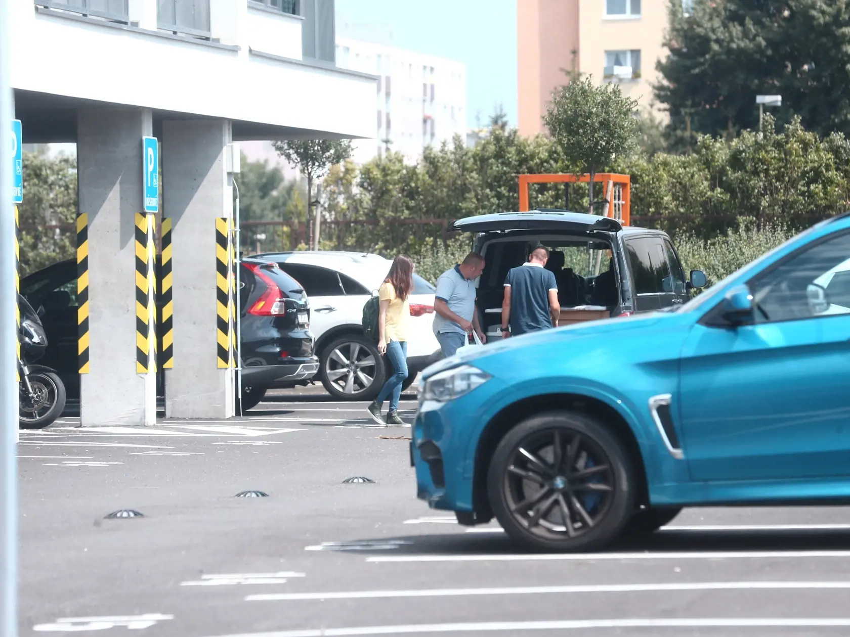 "Kuriéri" otvárajú auto, tašku od Troškovej dávajú do vnútra dodávky