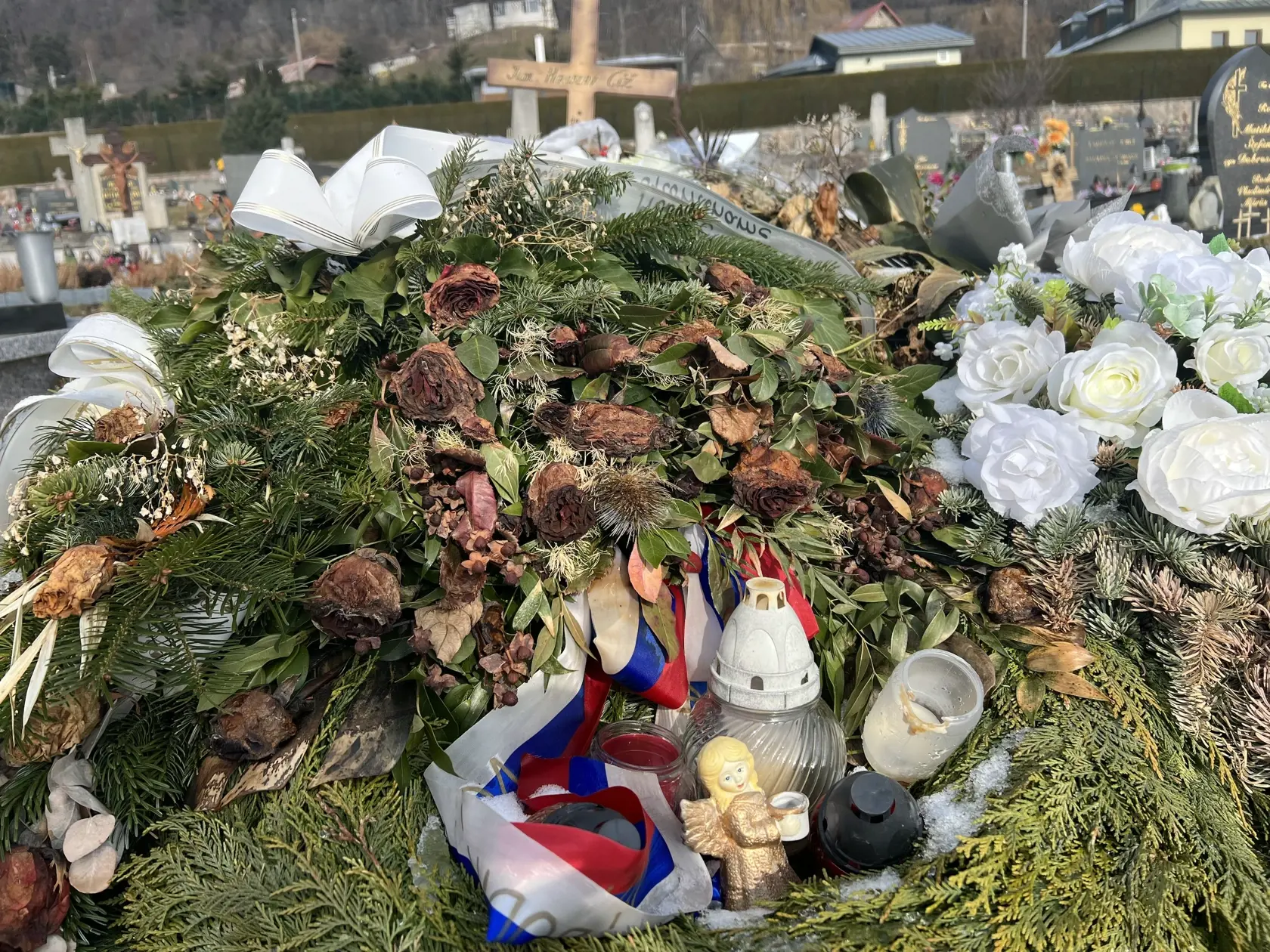 Namiesto pomníka tu dočasne stojí len jednoduchý drevený kríž a hrob pôsobí ako keby sa oň nik nestaral - ležia na ňom staré kvety ešte od pohrebu.