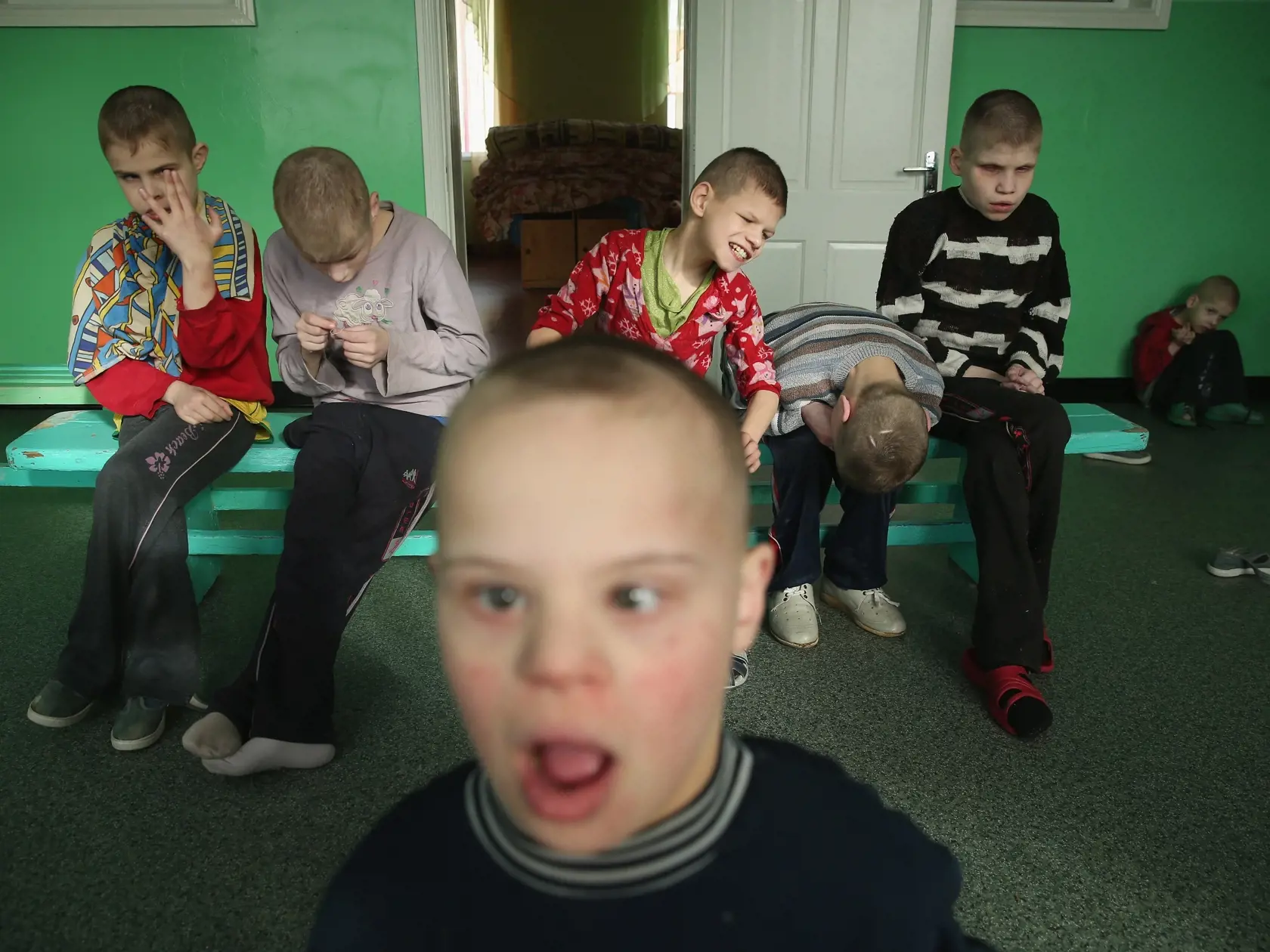 GLUSK, BELARUS - APRIL 03:  Severly-handicapped boys sit on a bench in their wing at the Vesnova Home for Invalid Children on April 3, 2016 in Vesnova village near Glusk, Belarus. Approximately 170 handicapped children and teenagers, many of whom were born with severe birth defects, receive care at the facility located in southen Belarus, not far from zones contaminated by radiation from the 1986 Chernobyl nuclear accident. Scientific debate is ongoing over whether congenital birth defects can b