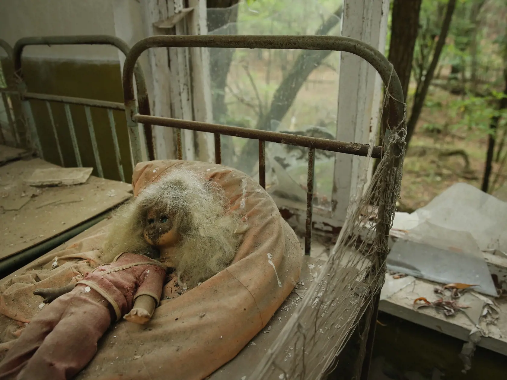 CHORNOBYL, UKRAINE - SEPTEMBER 29:  A doll lies among children's beds standing in the abandoned kindergarten of Kopachi village located inside the Chernobyl Exclusion Zone on September 29, 2015 near Chornobyl, Ukraine. Kopachi, a village that before 1986 had a population of 1,114, lies only a few kilometers south of the former Chernobyl nuclear power plant, where in 1986 workers inadvertantly caused reactor number four to explode, creating the worst nuclear accident in history. Radiation fallout
