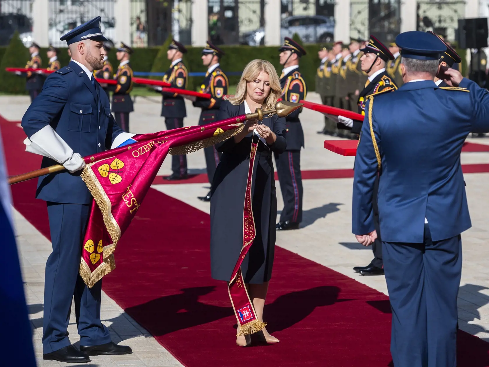 Na snímke prezidentka SR Zuzana Čaputová (uprostred) pripína stuhu na bojovú zástavu počas slávnostného ceremoniálu na prednom nádvorí Prezidentského paláca v Bratislave 7. septembra 2023. FOTO TASR - Jaroslav Novák