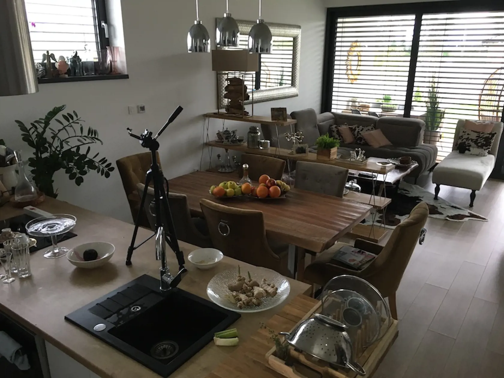 Od kuchynského pultu smeruje pohľad cez jedálenský stôl, sedačku až na terasu a do záhrady.