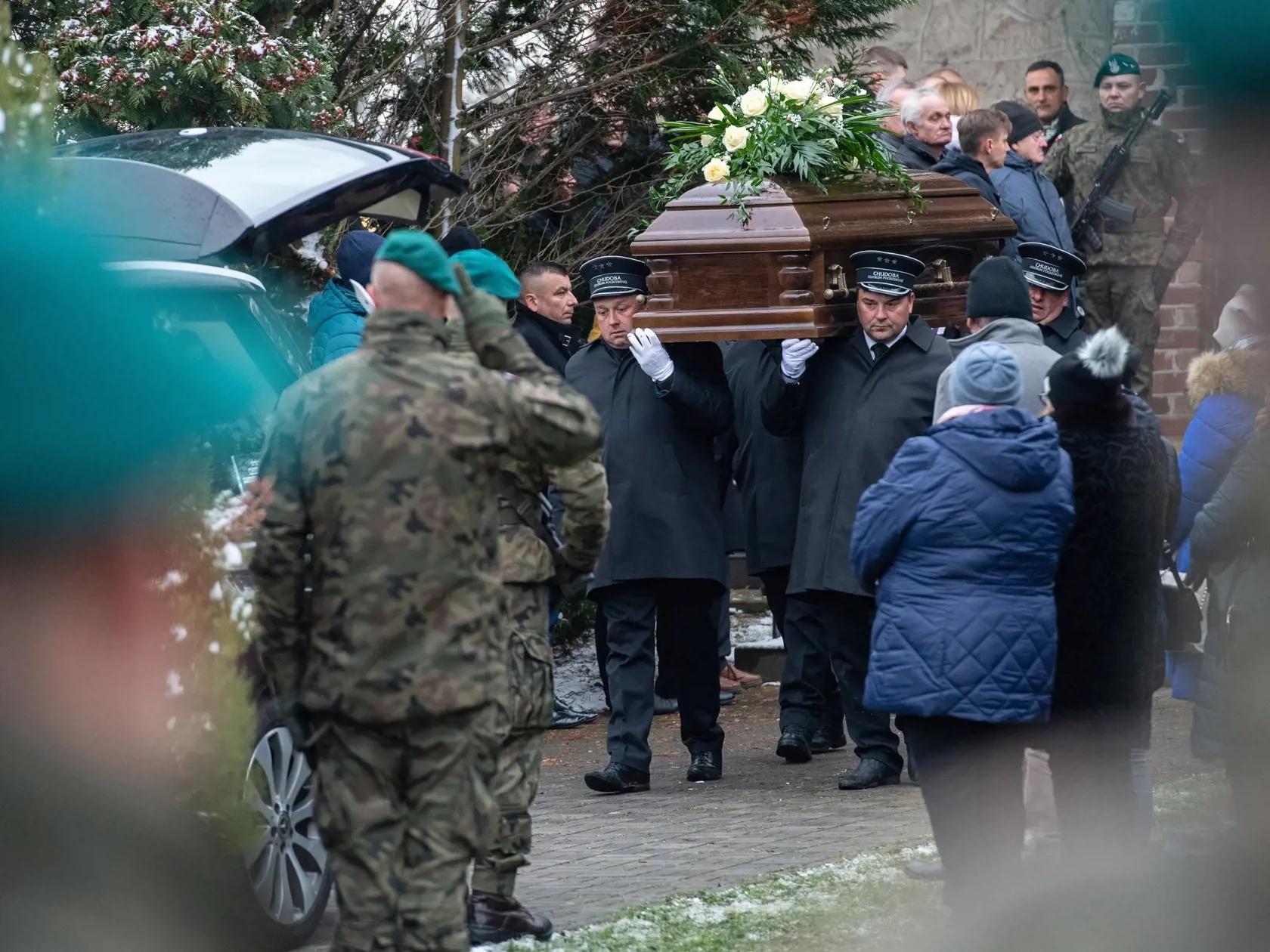Na snímke muži nesú truhlu s telom Boguslawa Wosa, jednej z dvoch obetí utorkového výbuchu, počas pohrebu v poľskej obci Przewodów 19. novembra 2022.