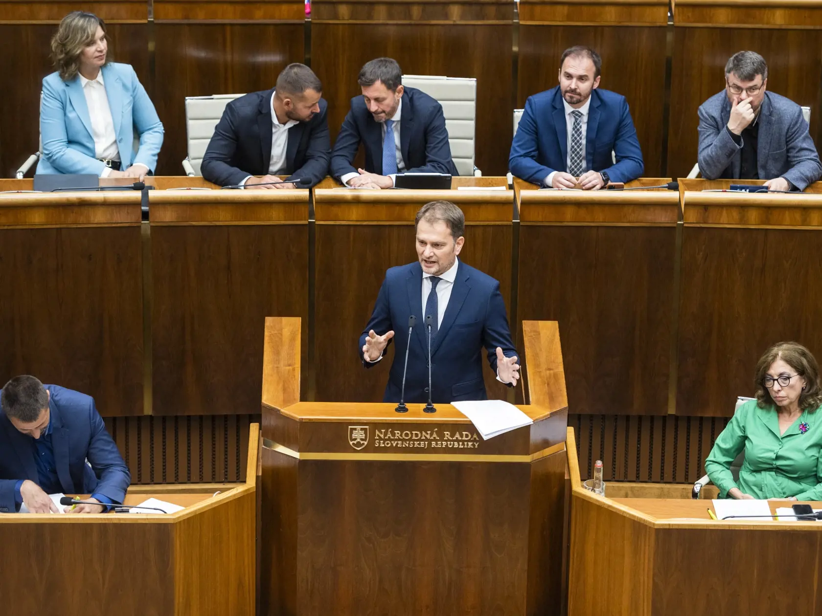 Zľava vrchný rad: podpredsedníčka vlády a ministerka investícií, regionálneho rozvoja a informatizácie Veronika Remišová (Za ľudí), poslanec NR SR Ľuboš Krajčír (Sme rodina), predseda vlády Eduard Heger (OĽaNO), poslanec NR SR Michal Šipoš (OĽaNO), podpredseda vlády pre legislatívu a strategické plánovanie Štefan Holý (Sme rodina). Zľava dole poslanec NR SR Marián Viskupič (SaS), podpredseda vlády a minister financií Igor Matovič (OĽaNO) a poslankyňa NR SR Anna Zemanová (SaS).