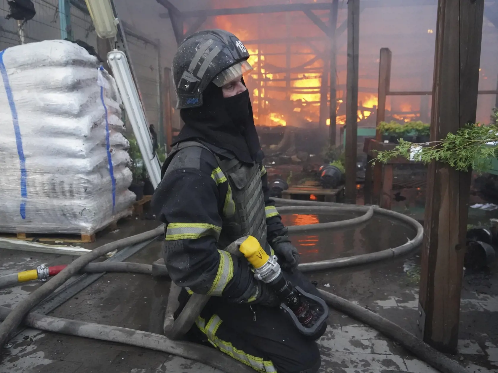 Hasič zasahuje po tom, čo dve ruské navádzané bomby zasiahli hypermarket Epicentr v meste Charkov na severovýchode Ukrajiny v sobotu 25. mája 2024.