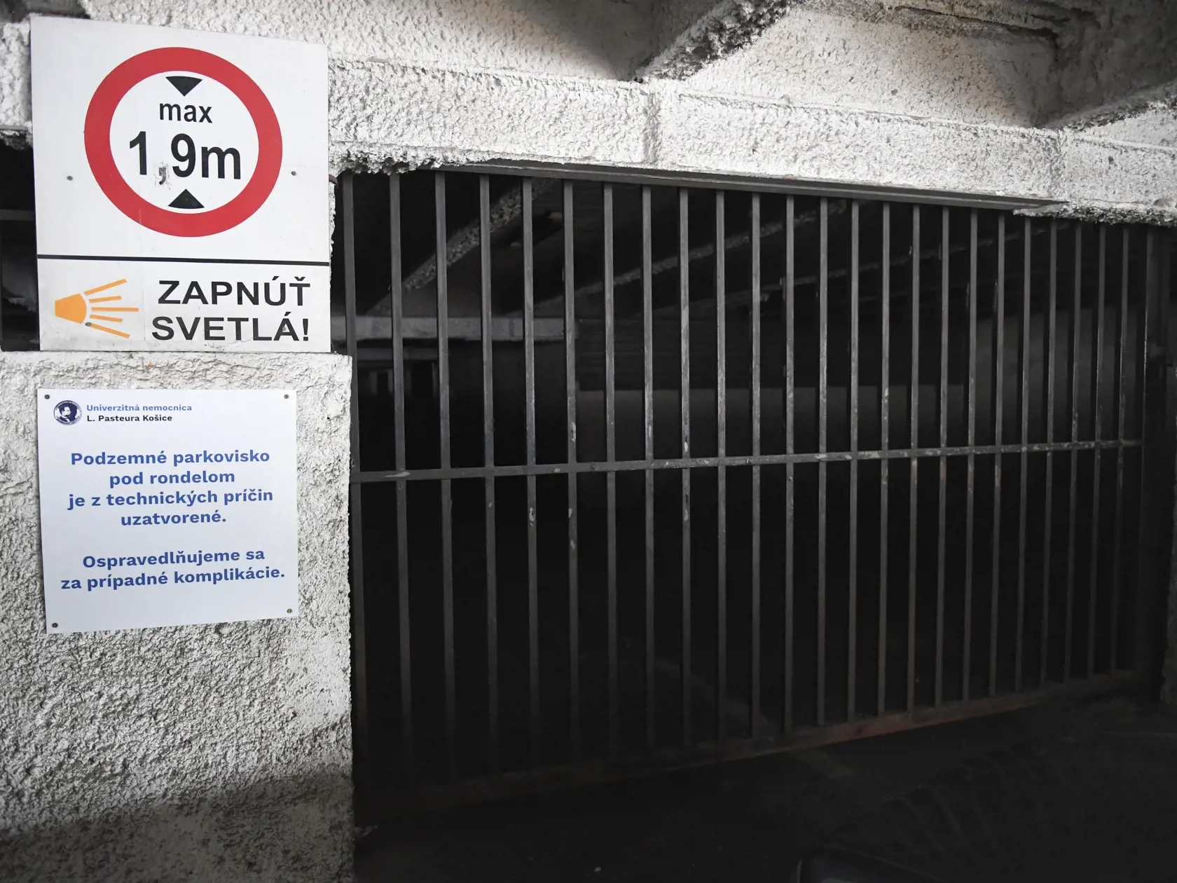 Univerzitná nemocnica Louisa Pasteura (UNLP) Košice po uzavretom moste uzavrela aj kryté podzemné parkovisko, ktoré je v havarijnom stave a tak sa parkovanie v nemocnici ešte viac skomplikuje. Priestranstvo nad krytým parkoviskom je tiež v zlom stave, technická kontrola ukáže, či bude nevyhnutné uzavrieť aj túto plochu. Na snímke uzavretý vchod na podzemné parkovisko. Košice, 18. októbra 2021. FOTO TASR – František Iván