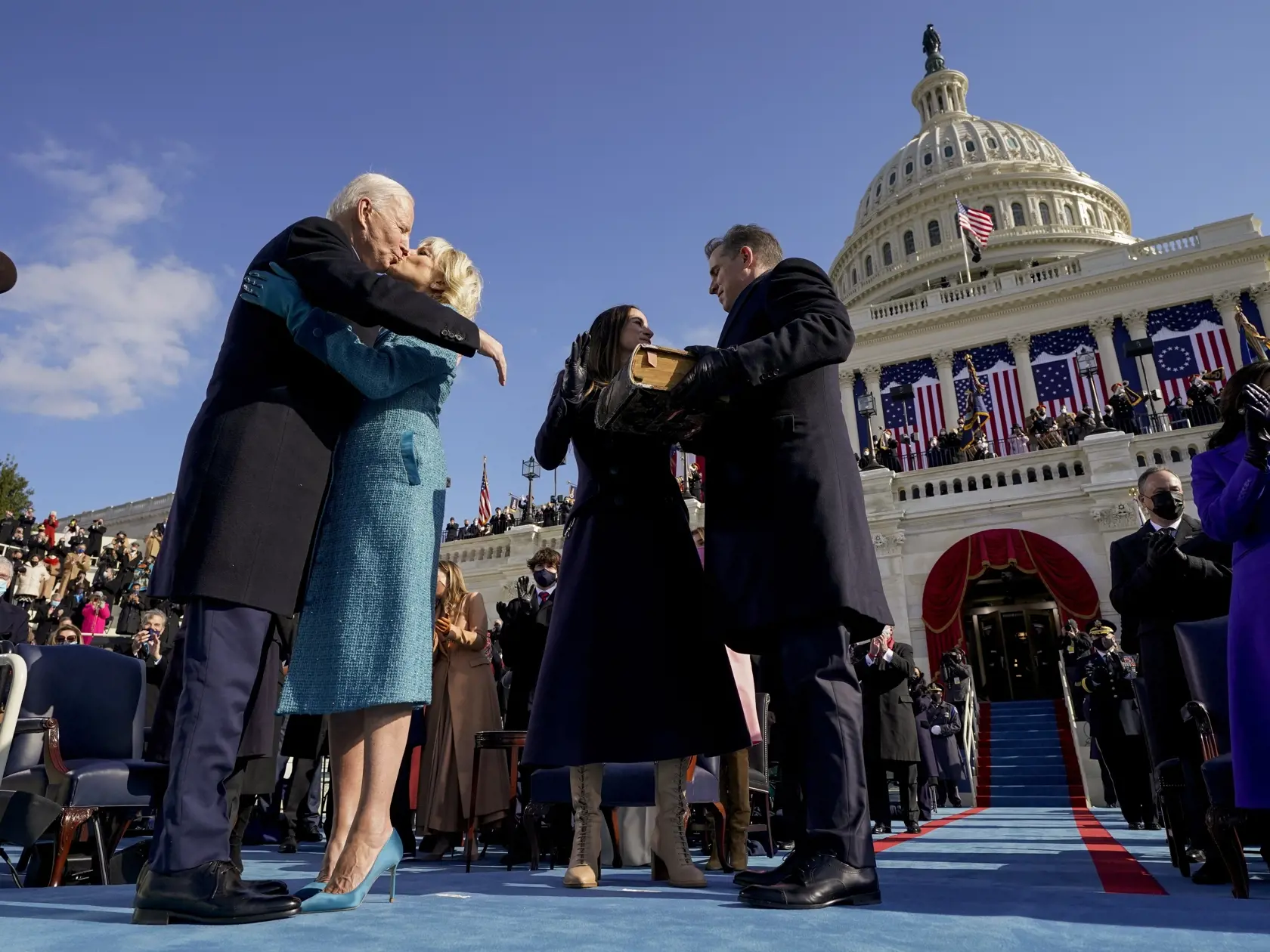 Americký prezident Joe Biden  (vľavo) bozkáva svoju manželku Jill Bidenovú a za nimi stoja ich deti, syn Hunter Biden a dcéra Ashley Bidenová po inaugurácii 46. prezidenta USA Joea Bidena a 49. viceprezidentky Kamaly Harrisovej v americkom Kapitole vo Washingtone 20. januára 2021.