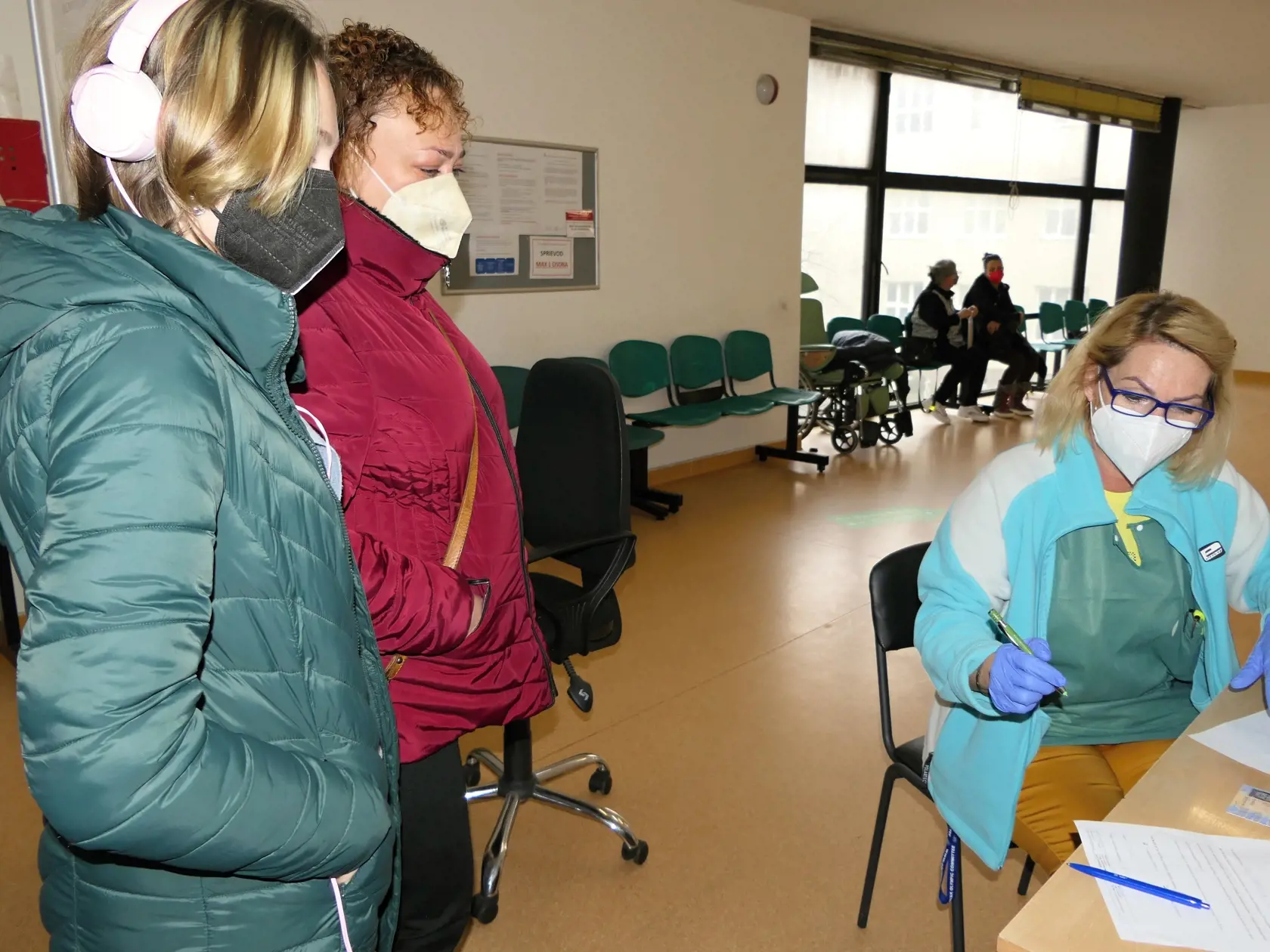 Na snímke rodič s maloletým dievčaťom počas vypĺňania formulárov potrebných na očkovanie proti ochoreniu COVID-19 vo Fakultnej nemocnici s poliklinikou v Žiline dňa 27. novembra 2021. FOTO TASR - Erika Ďurčová