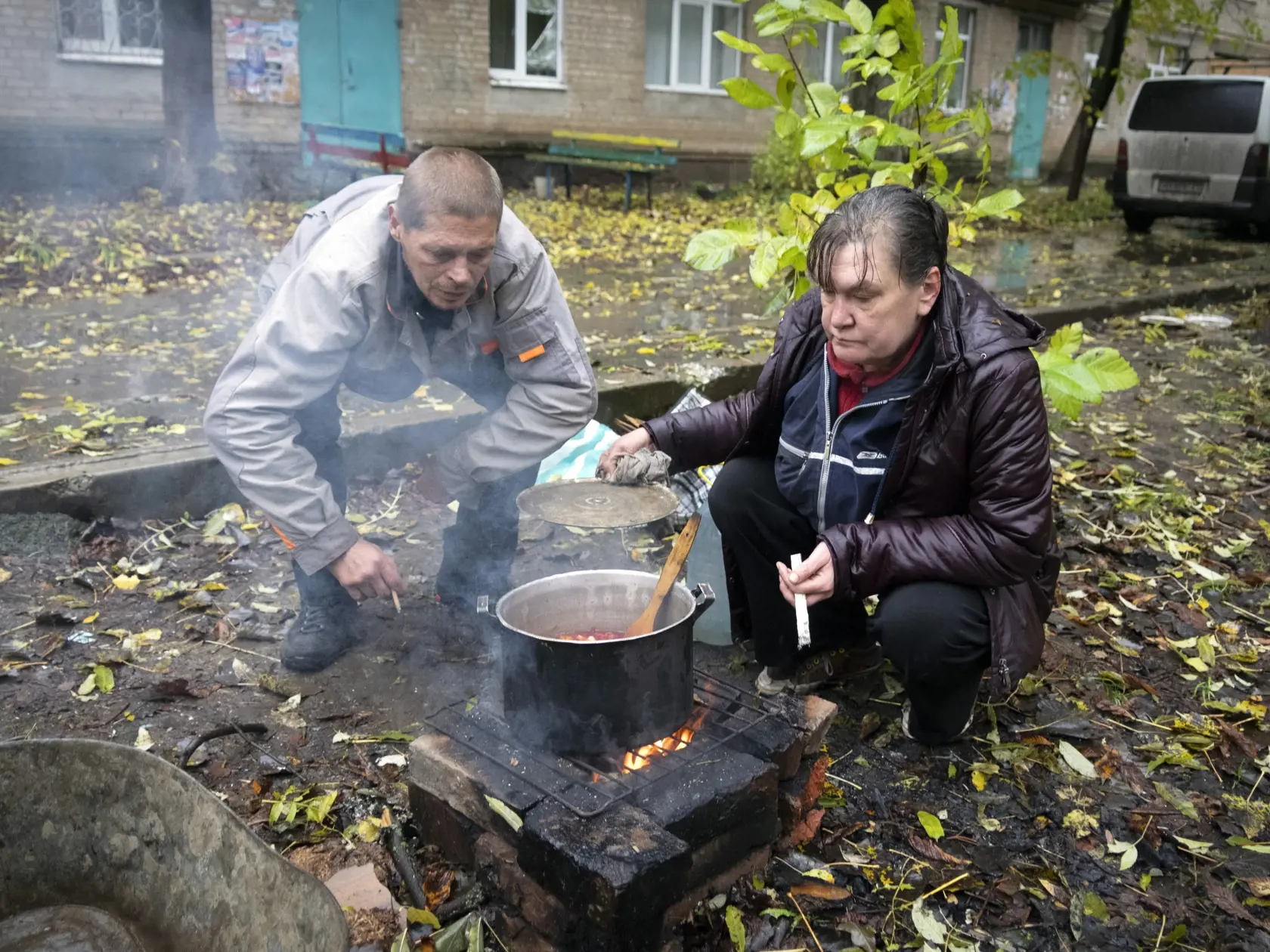 Miestny obyvatelia si veria pred bytovkou v meste Bachmut vo východoukrajinskej Doneckej oblasti v stredu 26. októbra 2022.