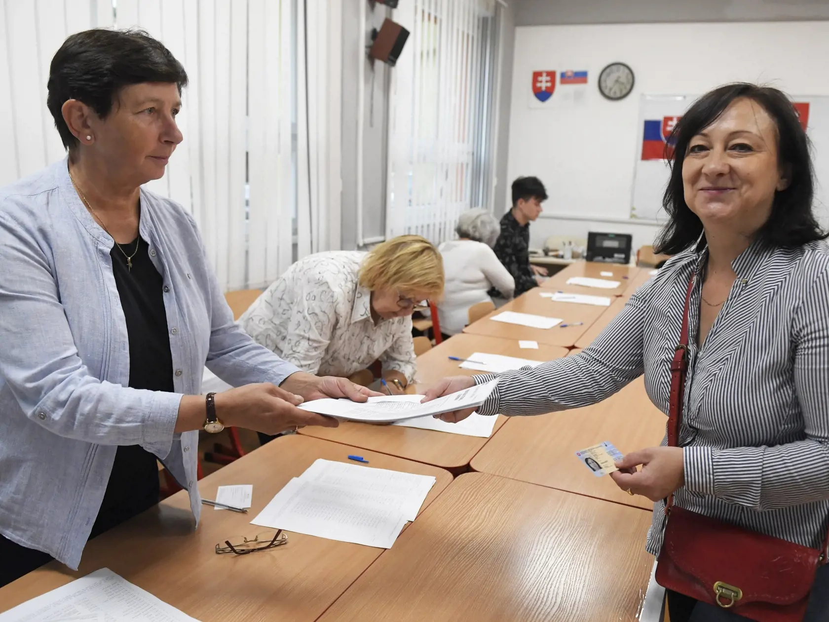 Na Slovensku sa v sobotu o 7.00 h začali v poradí štvrté predčasné a celkovo deviate parlamentné voľby v ére samostatnej SR. Na snímke volička sa preukazuje občianskym preukazom členke okrskovej volebnej komisie vo volebnej miestnosti v Gymnáziu Park mládeže v Košiciach počas predčasných parlamentných volieb na Slovensku v sobotu 30. septembra 2023. FOTO TASR - František Iván 