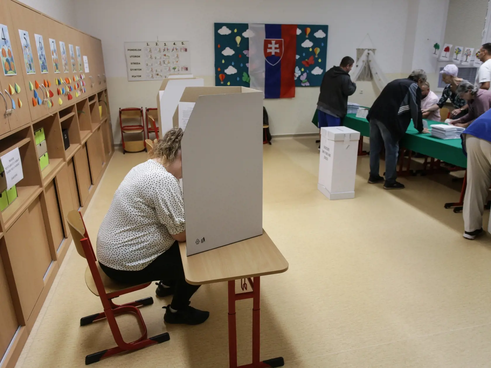 Na Slovensku sa v sobotu o 7.00 h začali v poradí štvrté predčasné a celkovo deviate parlamentné voľby v ére samostatnej SR. Na snímke volička za priestorom na úpravu hlasovacích lístkov  vo volebnej miestnosti v priestoroch Základnej školy na Karpatskej ulici počas predčasných parlamentných volieb na Slovensku v sobotu 30. septembra 2023. FOTO TASR - Daniel Stehlík 