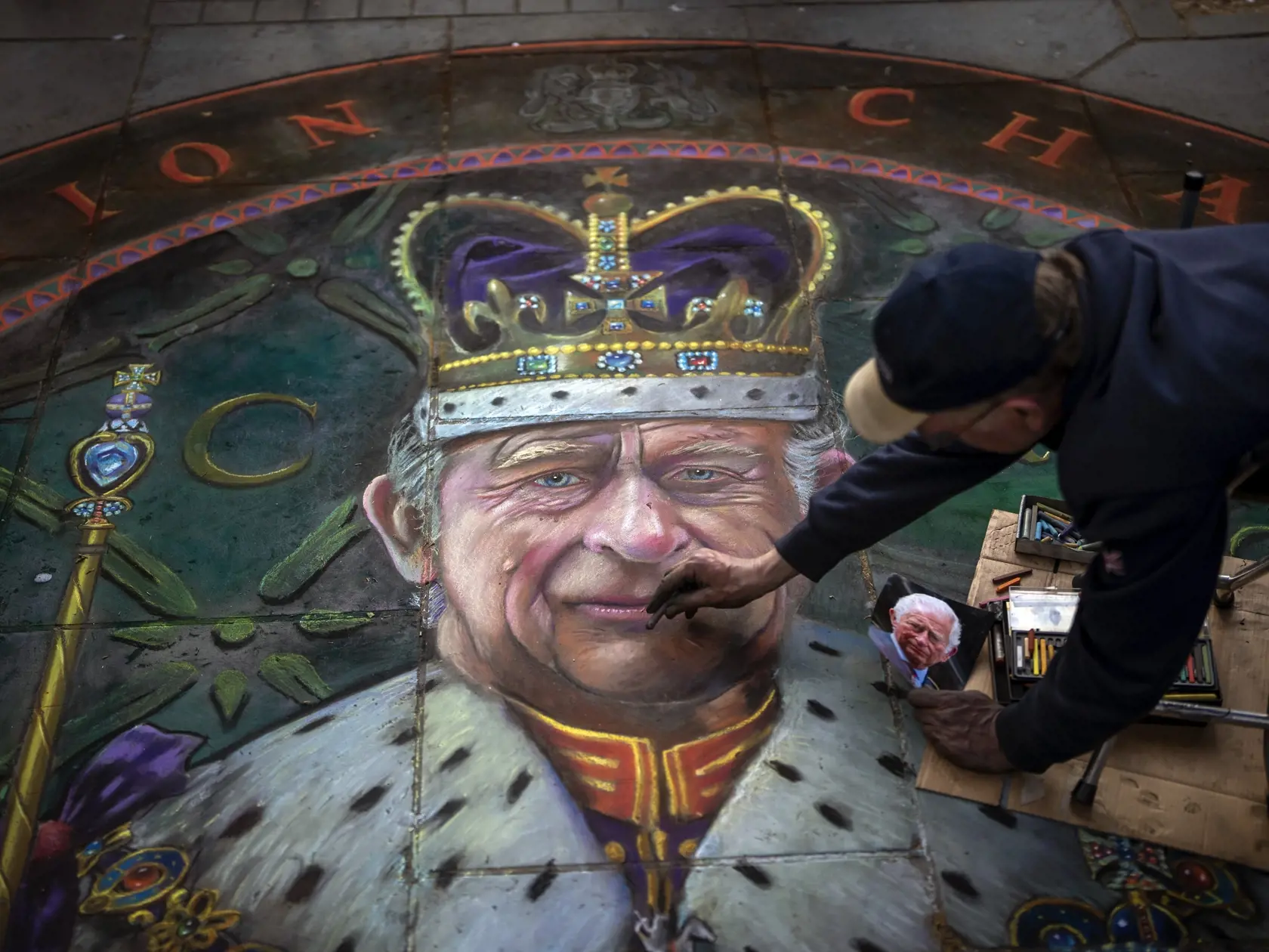 Na snímke britský umelec Julian Beaver dokončuje svoje dielo, ktoré zobrazuje britského kráľa Charlesa III. v Londýne 4. mája 2023.