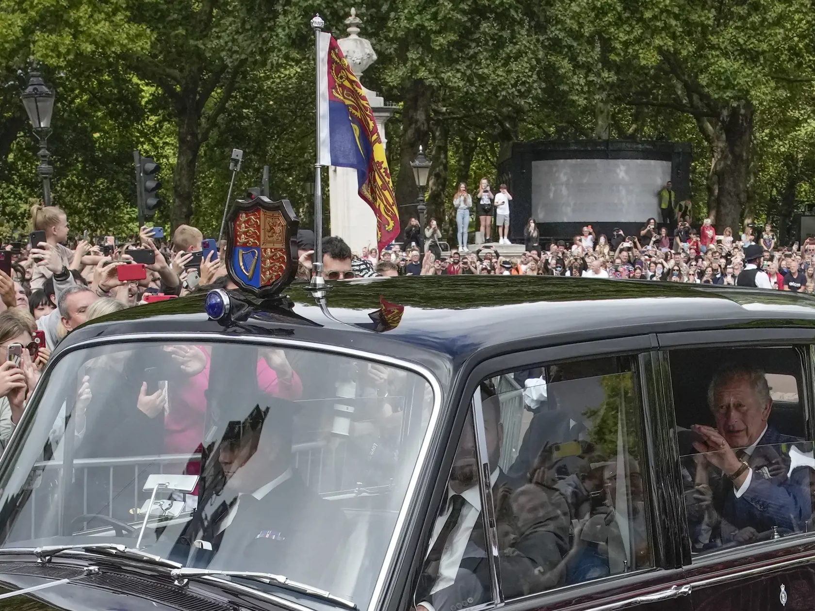 Na snímke britský kráľ Charles III. (vpravo) máva občanom, keď jeho konvoj vstupuje do Buckinghamského paláca  v Londýne 10. septembra 2022.